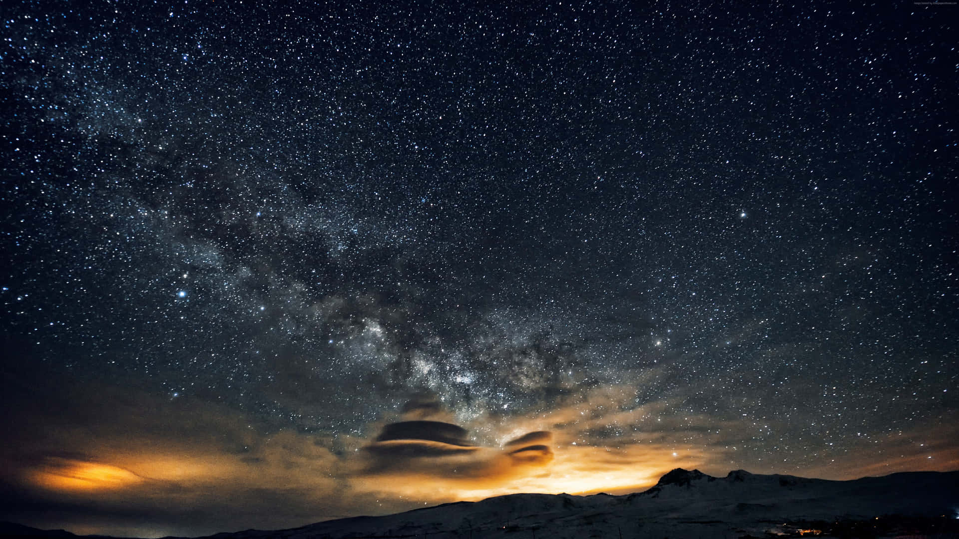 發光雲彩下星空中的雪山