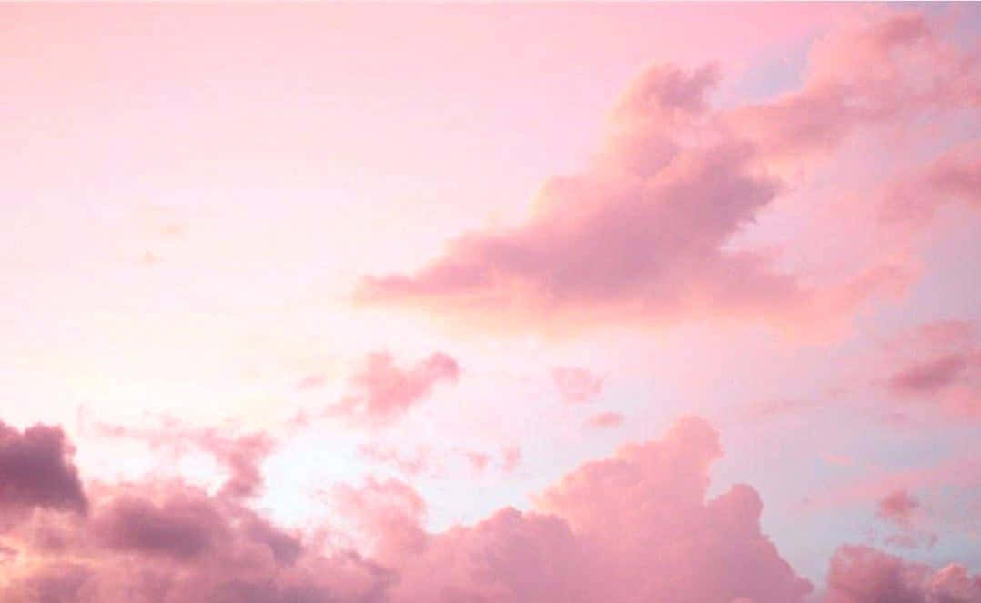探索這款柔美淺粉色視覺的_pastel_美學 壁紙 — 柔和的粉紅雲朵在暮色中飄過粉彩色的天空，帶有柔和的漸變和夢幻般的燈光。