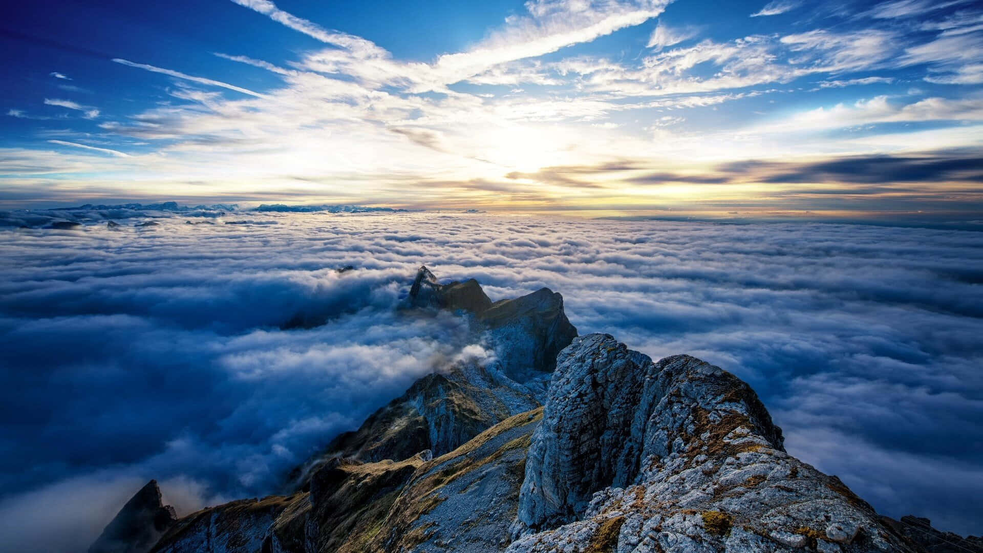 日出時雲海上的山峰，藍天和金色光芒