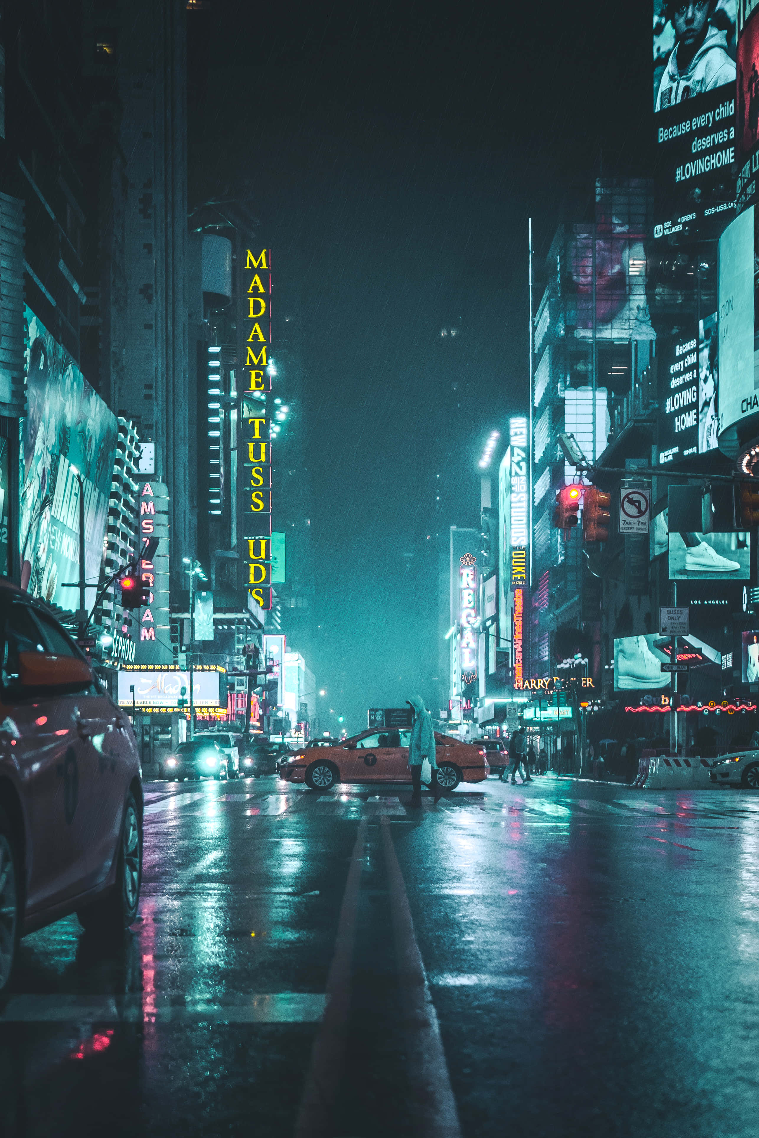 探索霓虹城市景觀的迷人之美 壁紙 — 時代廣場的雨夜，霓虹燈光在濕漉漉的人行道上反射，一輛黃色的士在街上行駛。