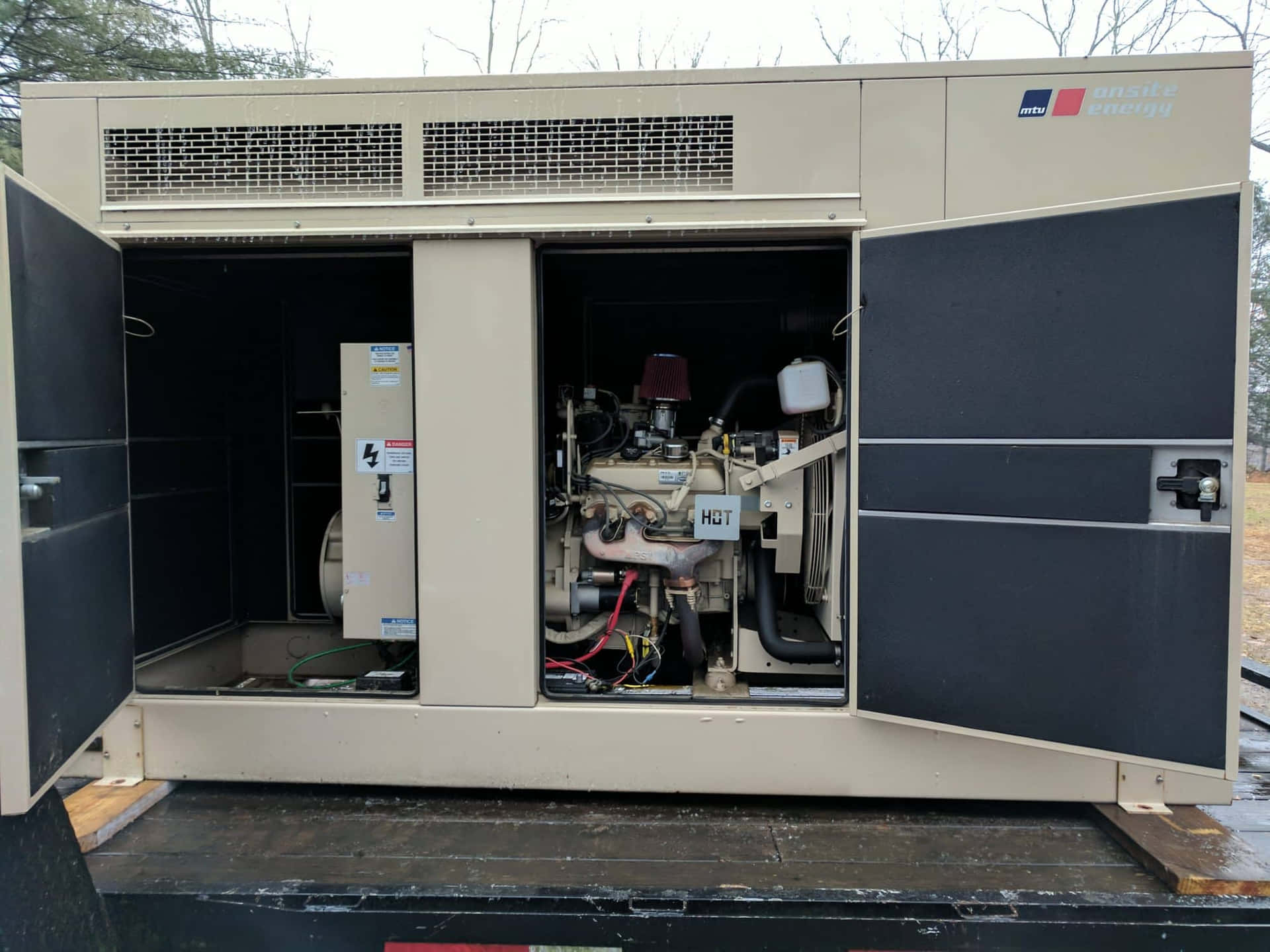 米色工業發電機，門打開顯示卡車車斗上的引擎。