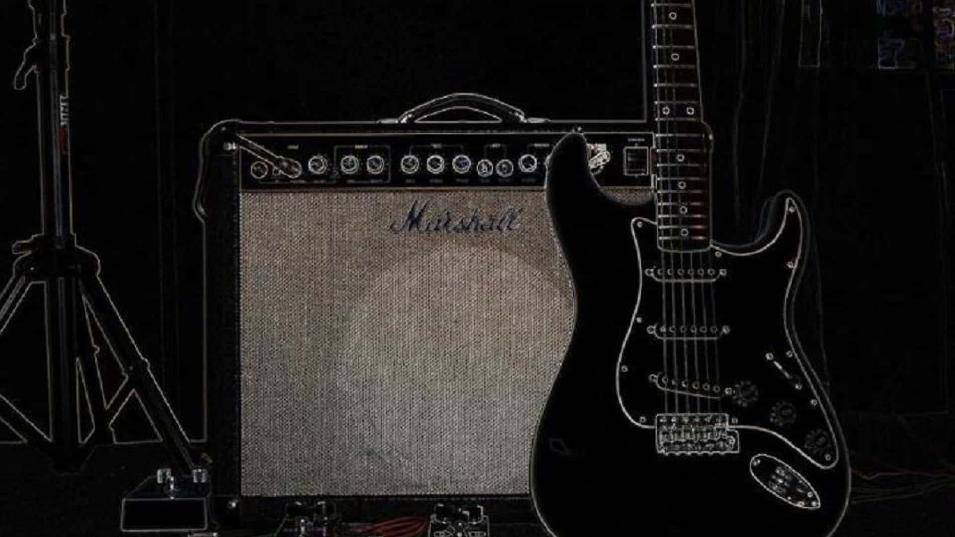 提升你的吉他音色 壁紙 — 一把黑色電結他靠在Marshall擴音機上，在昏暗的錄音室中，附近有一個咪高峰架。