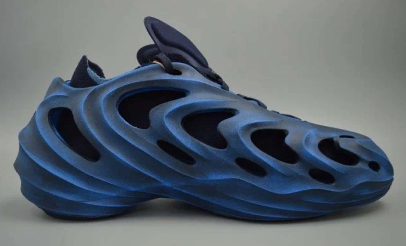 提升你的表現，穿上阿迪達斯 壁紙 — 一雙未來主義的藍色3D打印運動鞋，帶有流暢的有機曲線和鏤空切口，背景為中性灰色。