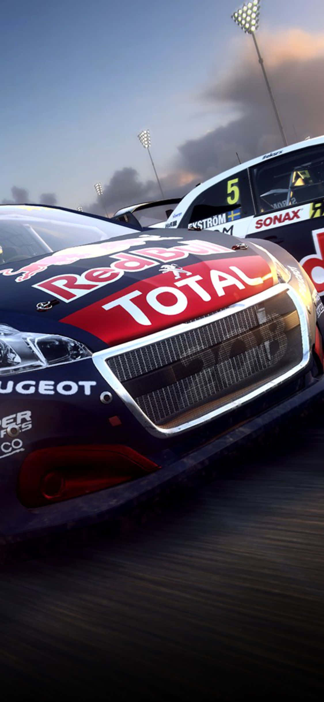 揭開 iPhone X 在《Dirt Rally》中的強大實力！ 壁紙 — 一輛帶有Red Bull和Total品牌標誌的高速賽車，在戲劇性的暮色天空下，在賽道上超越另一名競爭對手。