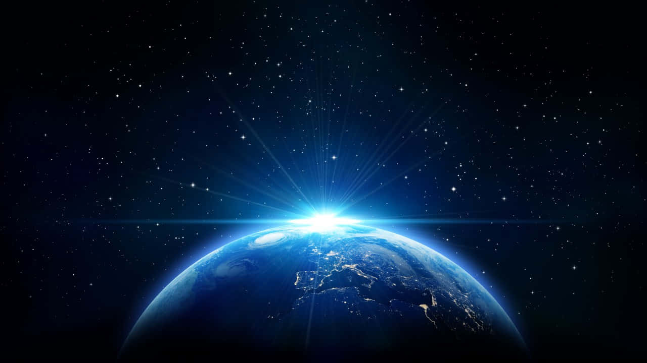 地球在繁星點點的夜空下因日出而發光。