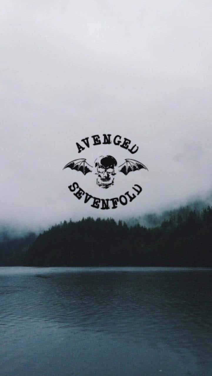 搖滾巨擘 — Avenged Sevenfold 樂隊影像 壁紙 — 一個被黑暗森林包圍的霧湖，黑色Avenged Sevenfold標誌漂浮在水面上。