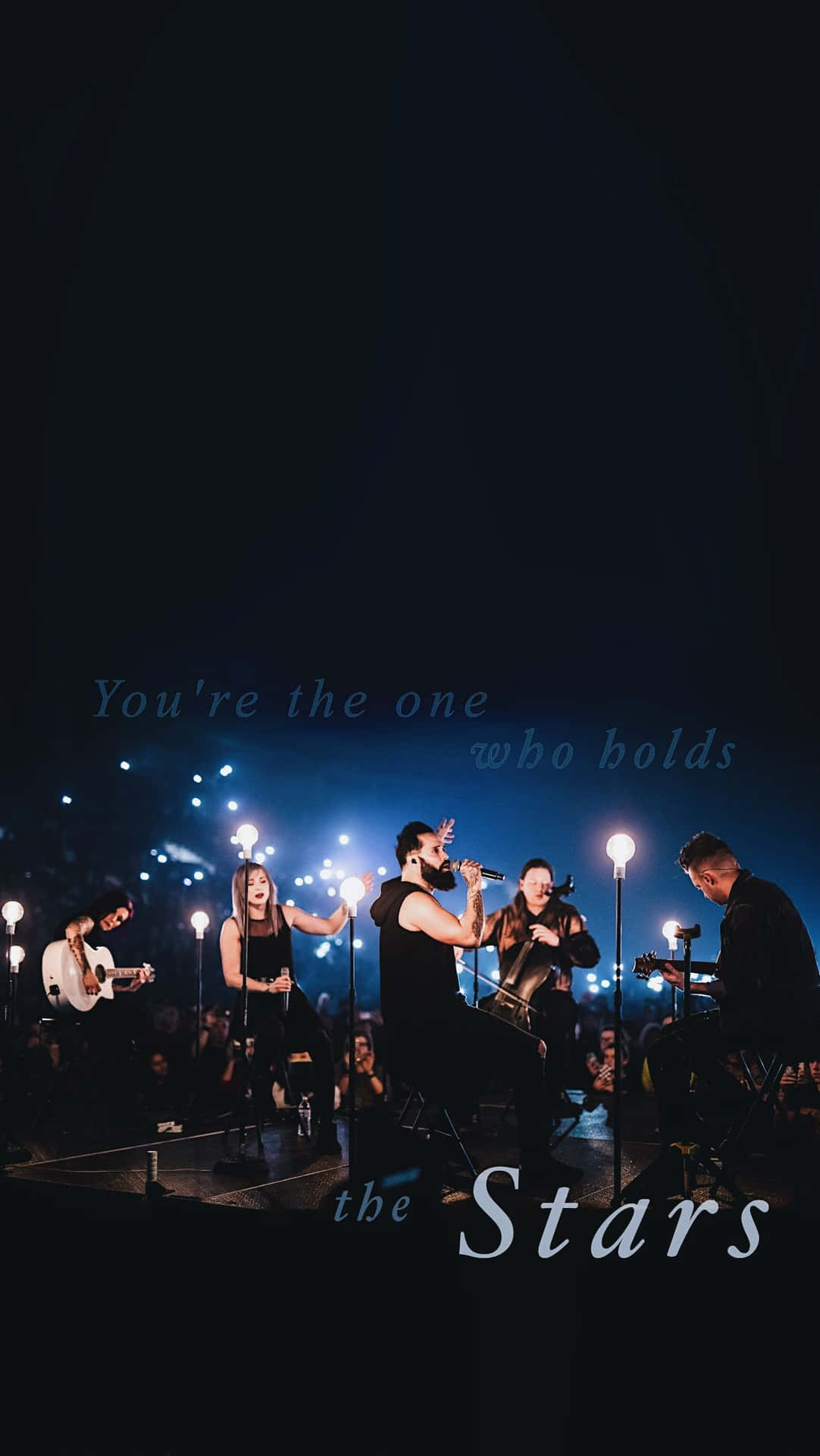 樂隊在舞台上現場表演，帶有藍色燈光和文字疊加，寫著 You're the one who holds the Stars.