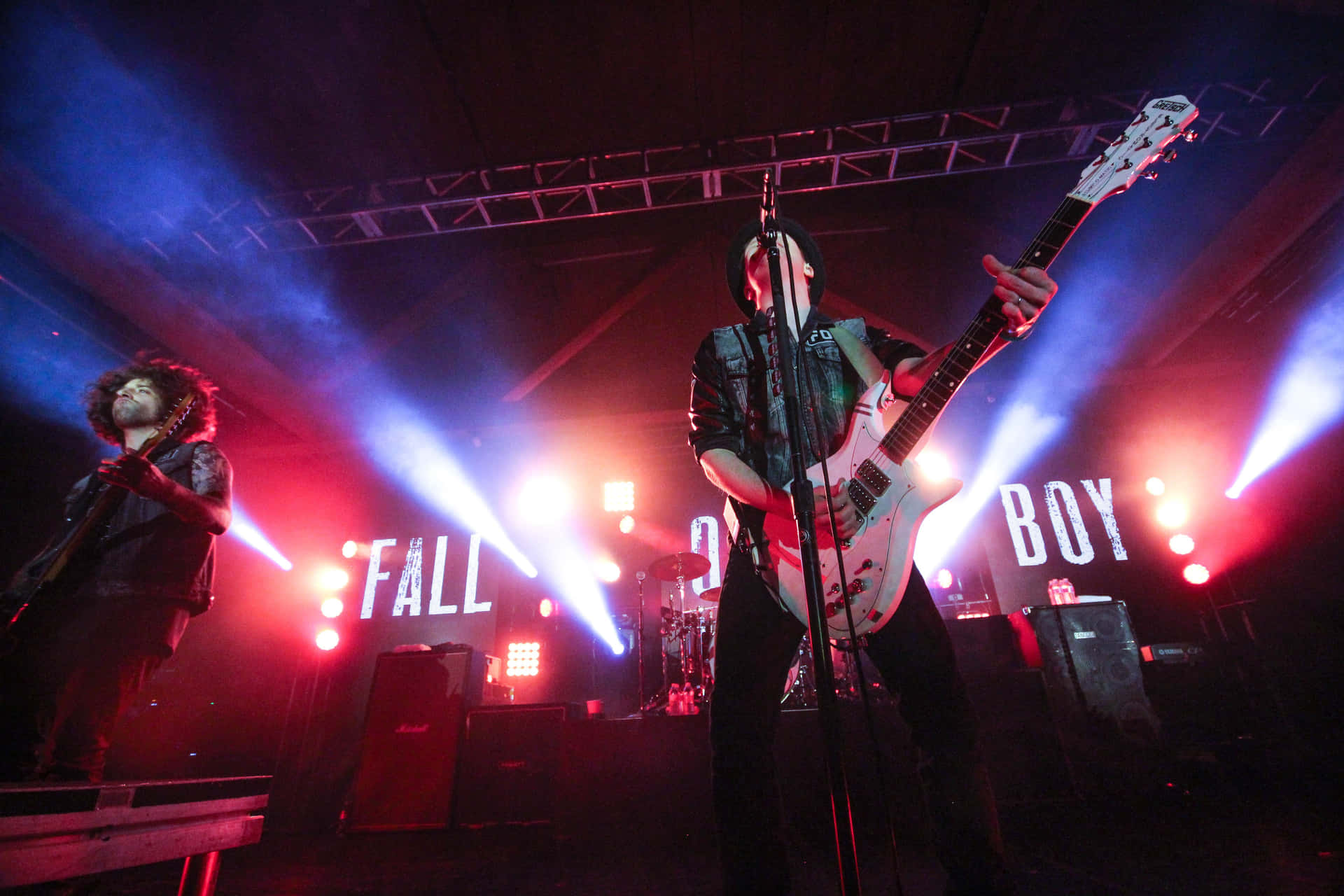 Fall Out Boy 樂隊在紅色和藍色燈光下現場表演。