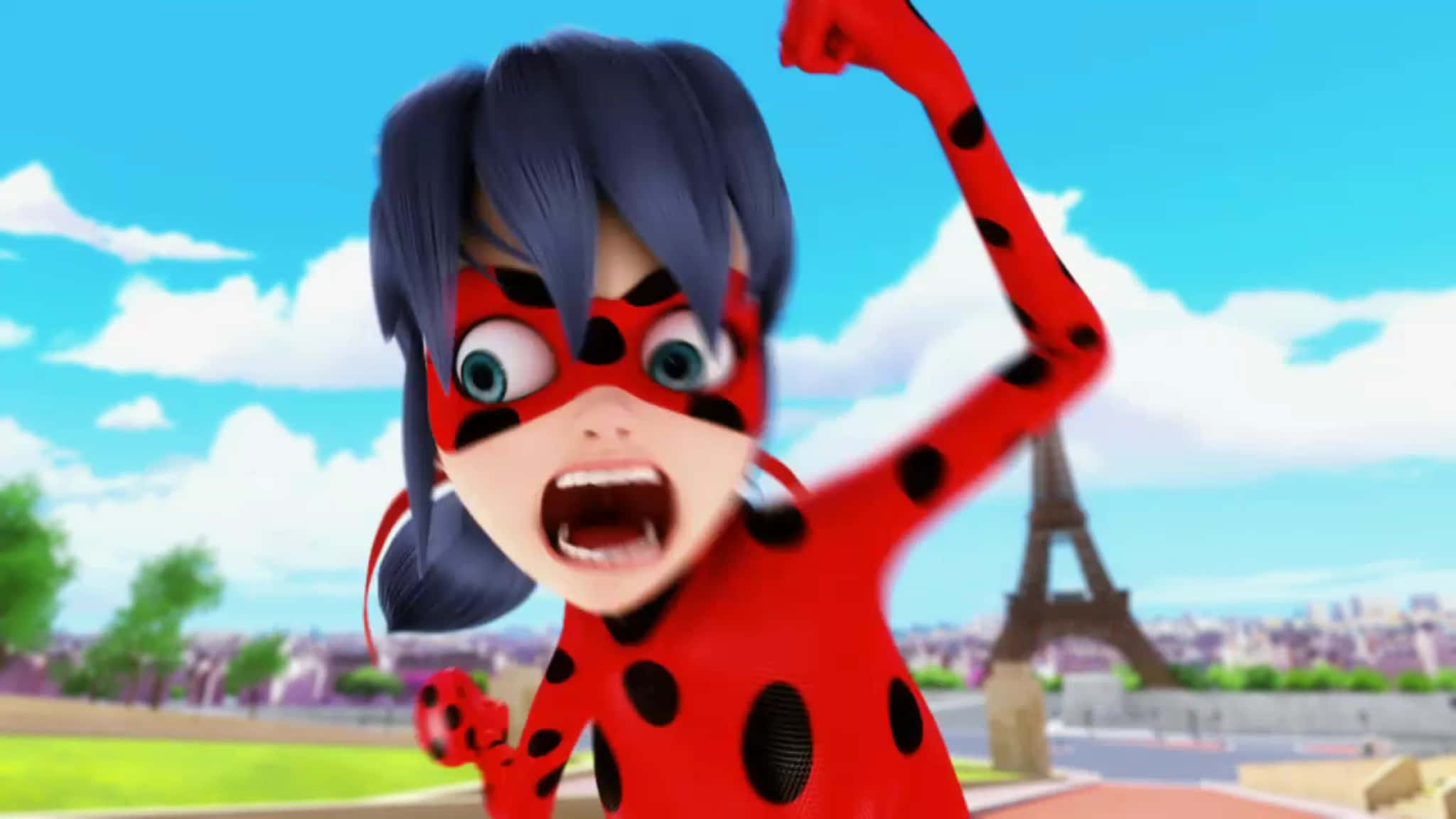 搞笑《Miraculous Ladybug》拳頭搞笑表情圖 壁紙 — 一位充滿活力的動畫超級女英雄，身穿紅黑圓點套裝，在巴黎天際線（包括艾菲爾鐵塔）前高舉拳頭，勝利的呼喊。