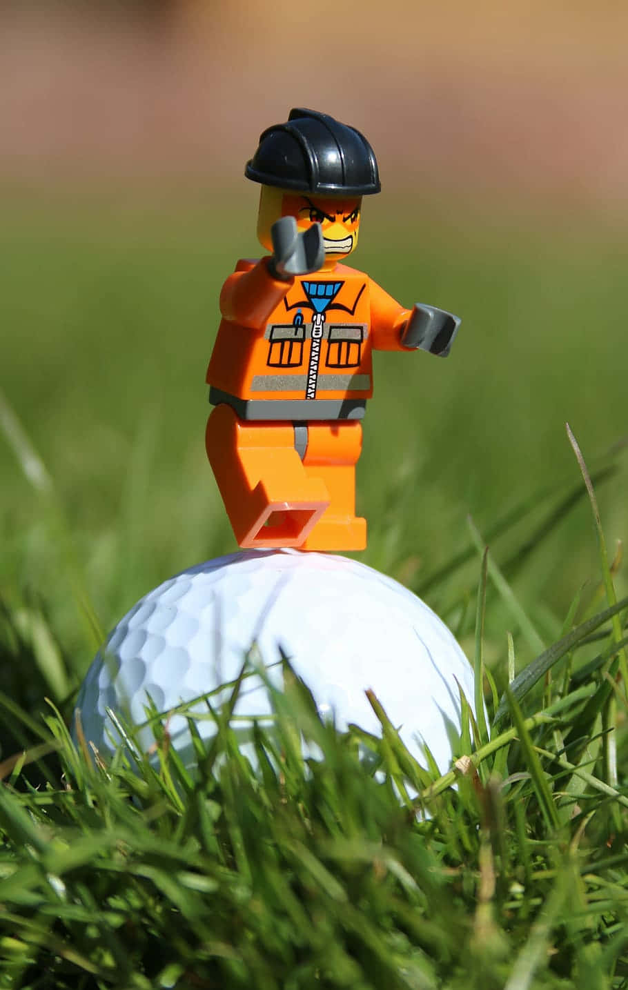LEGO建築工人站在草地上的高爾夫球上