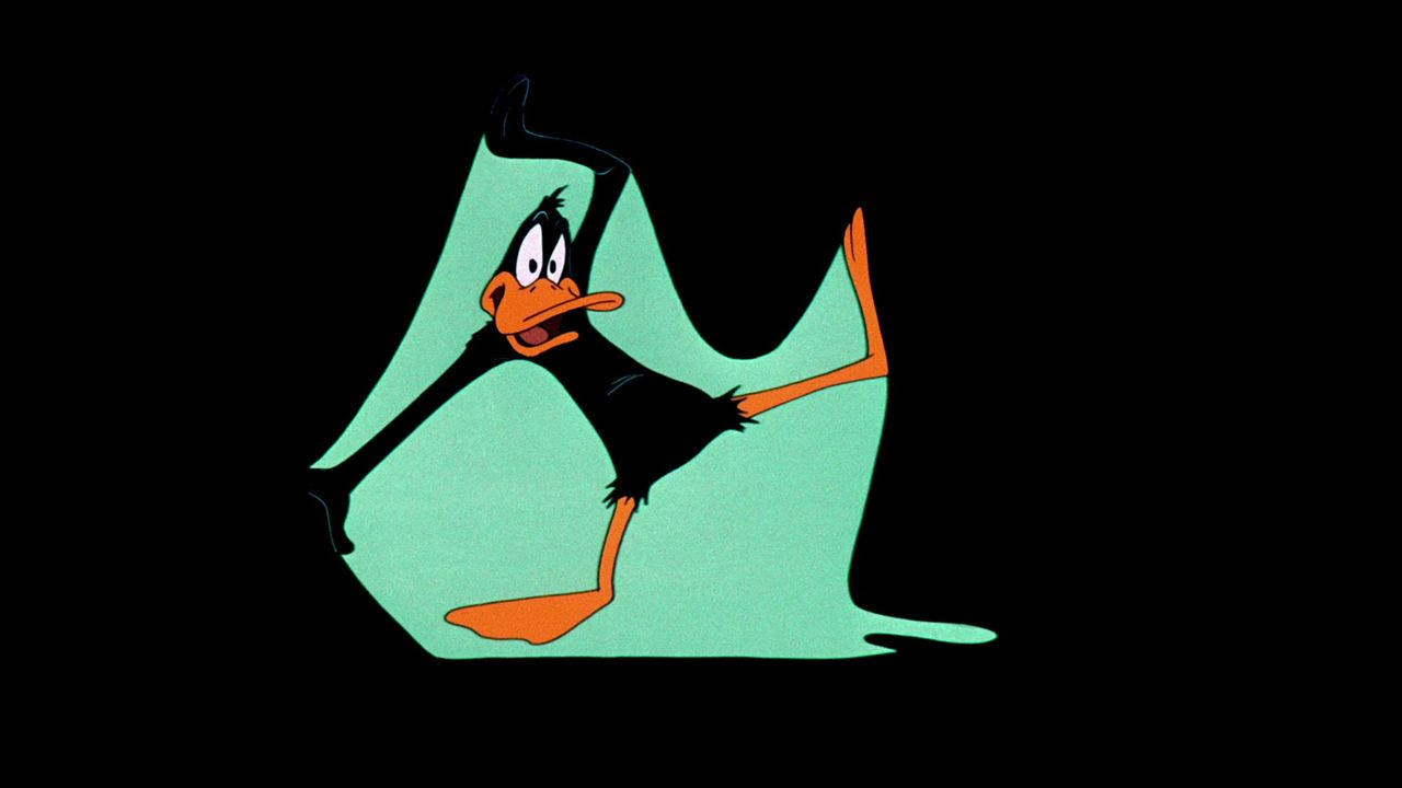 Daffy Duck 企喺一個青色水氹入面，舉起手臂同雙腿分開。