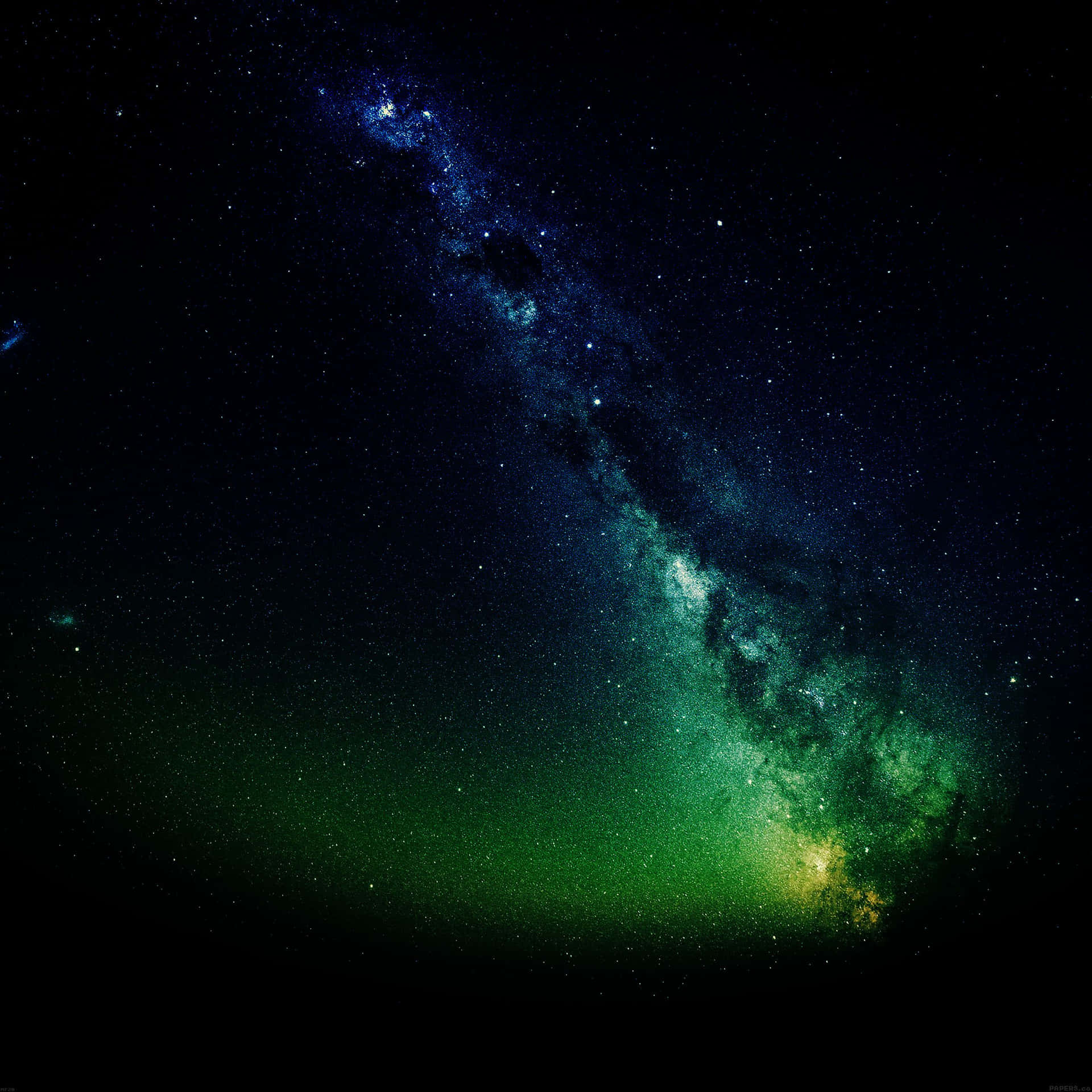 銀河系在繁星點點的夜空中散發出綠色和藍色的光芒。