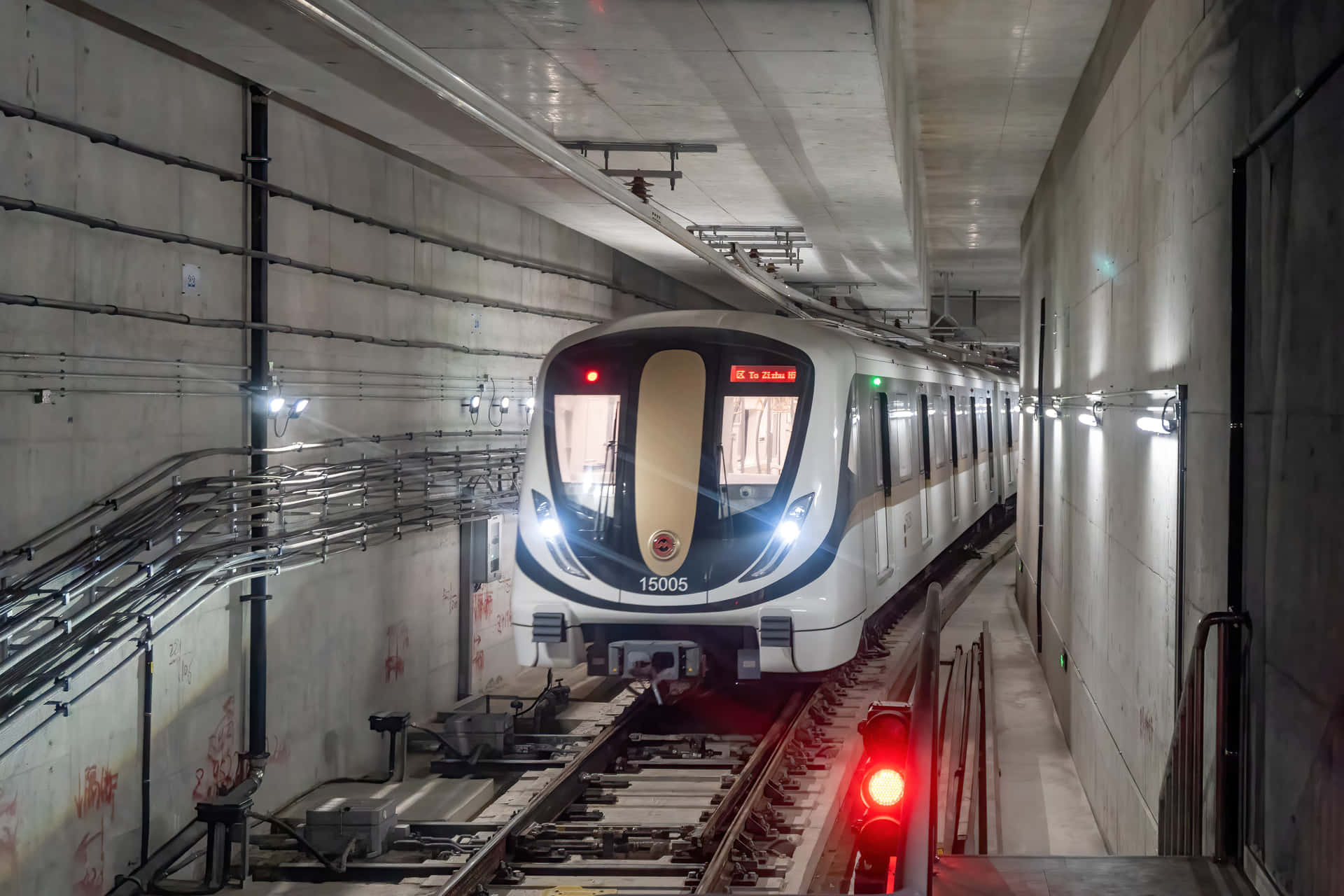 地鐵列車在帶有紅色信號燈的混凝土隧道中行駛。