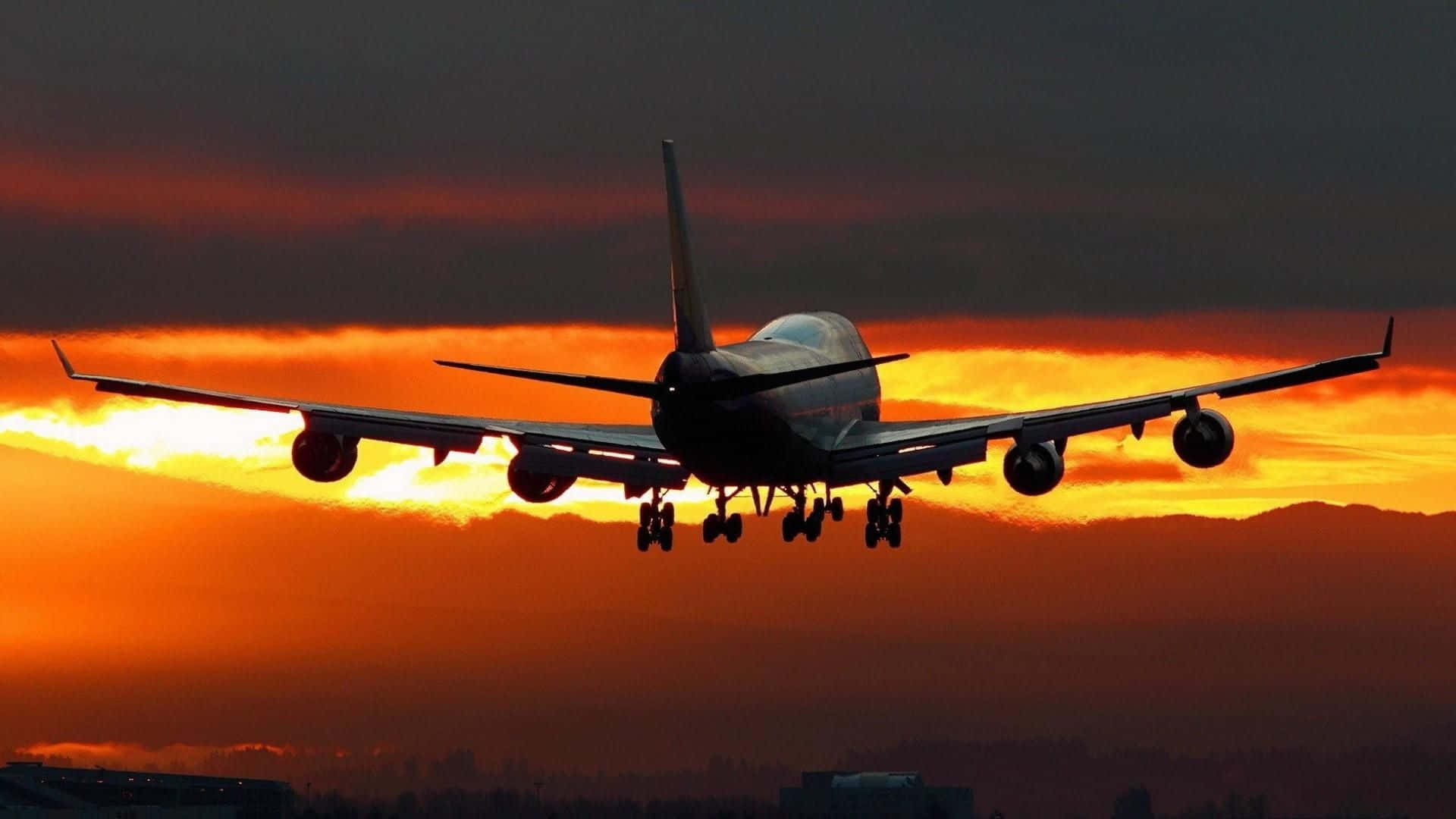 飛機在日落時分降落，天空呈現橙色和雲朵