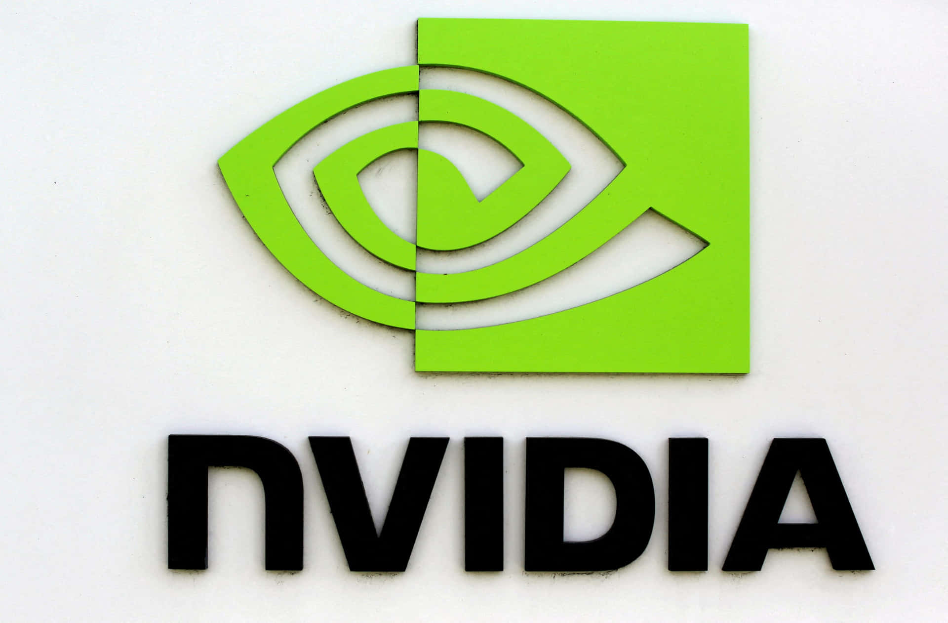 白色牆壁上帶有綠色眼睛符號和黑色文字的NVIDIA企業標誌。
