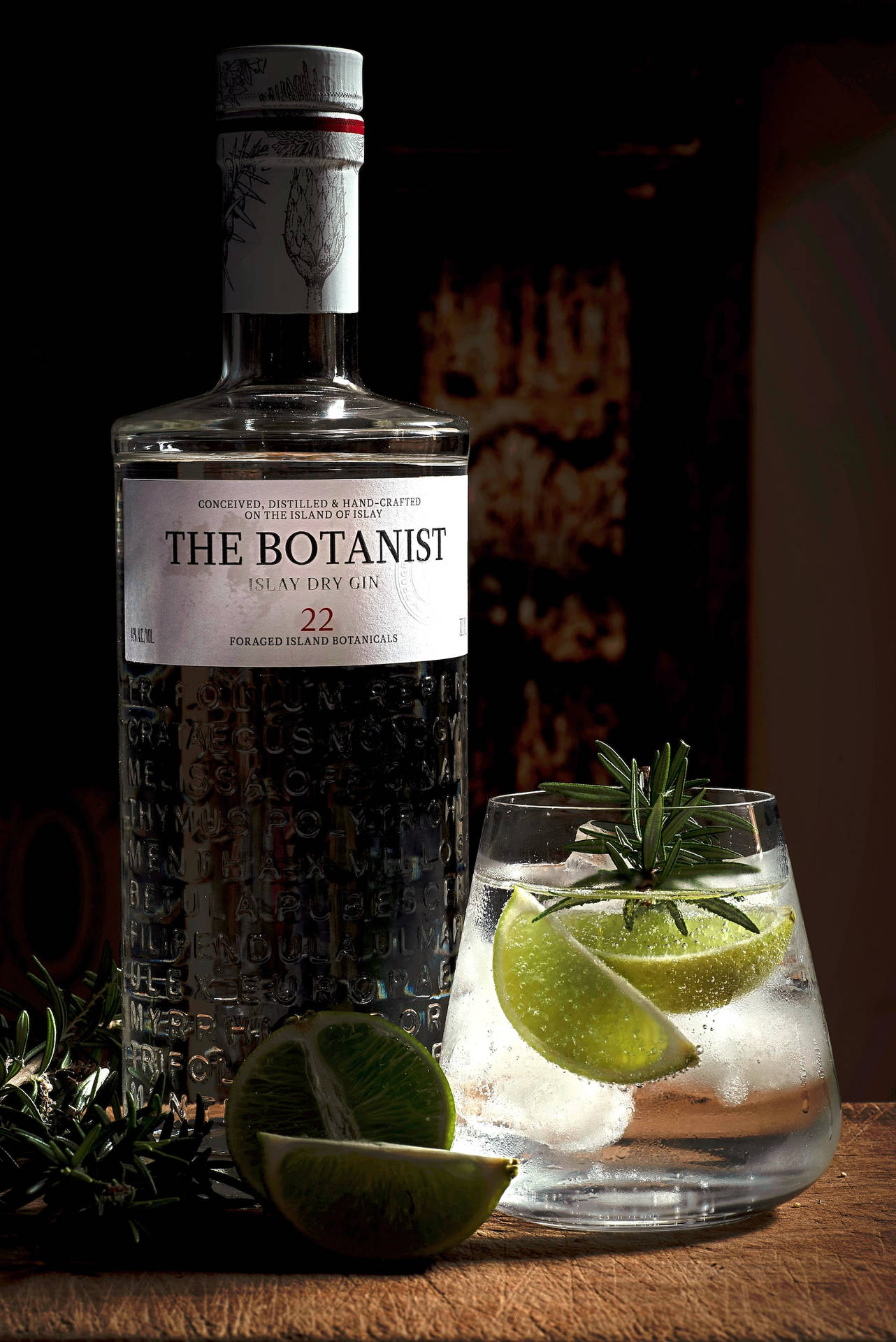 Botanist 氈酒瓶，配以青檸和迷迭香裝飾的雞尾酒，置於木上。