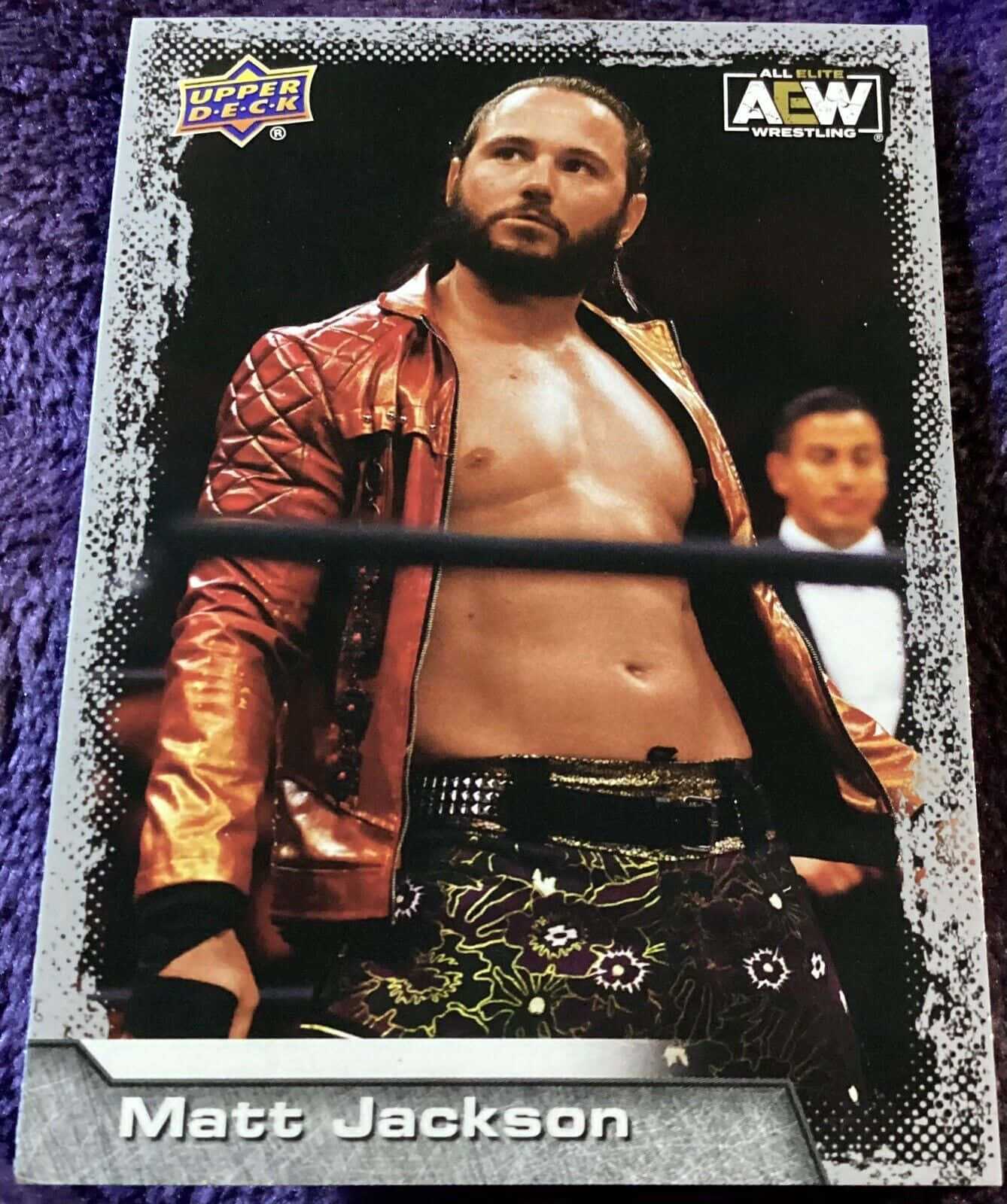 American Professional Wrestler Matt Jackson Upper Deck Trading Card 壁紙 — 摔角手Matt Jackson身穿閃亮金色外套和花卉圖案短褲，站在一張集換式卡牌中的摔角擂台上。