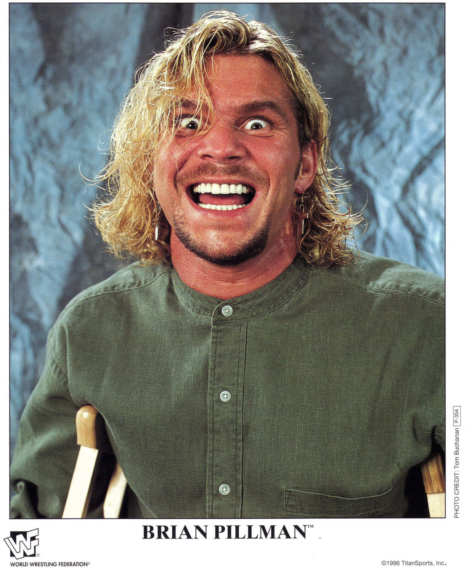 摔角手 Brian Pillman 喺影樓肖像中瞪大雙眼、一頭金髮大笑。
