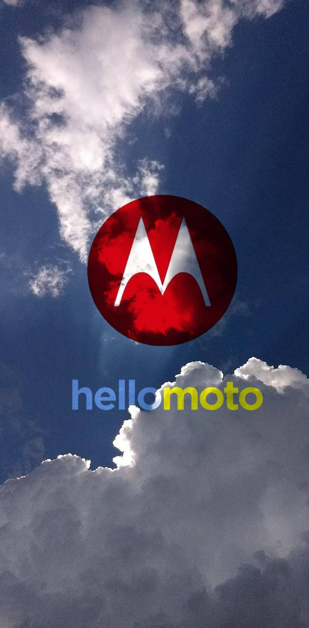 摩托羅拉紅色標誌懸浮於藍天 壁紙 — Motorola 標誌漂浮在戲劇性的藍天中，有蓬鬆的白雲和穿透而過的陽光。