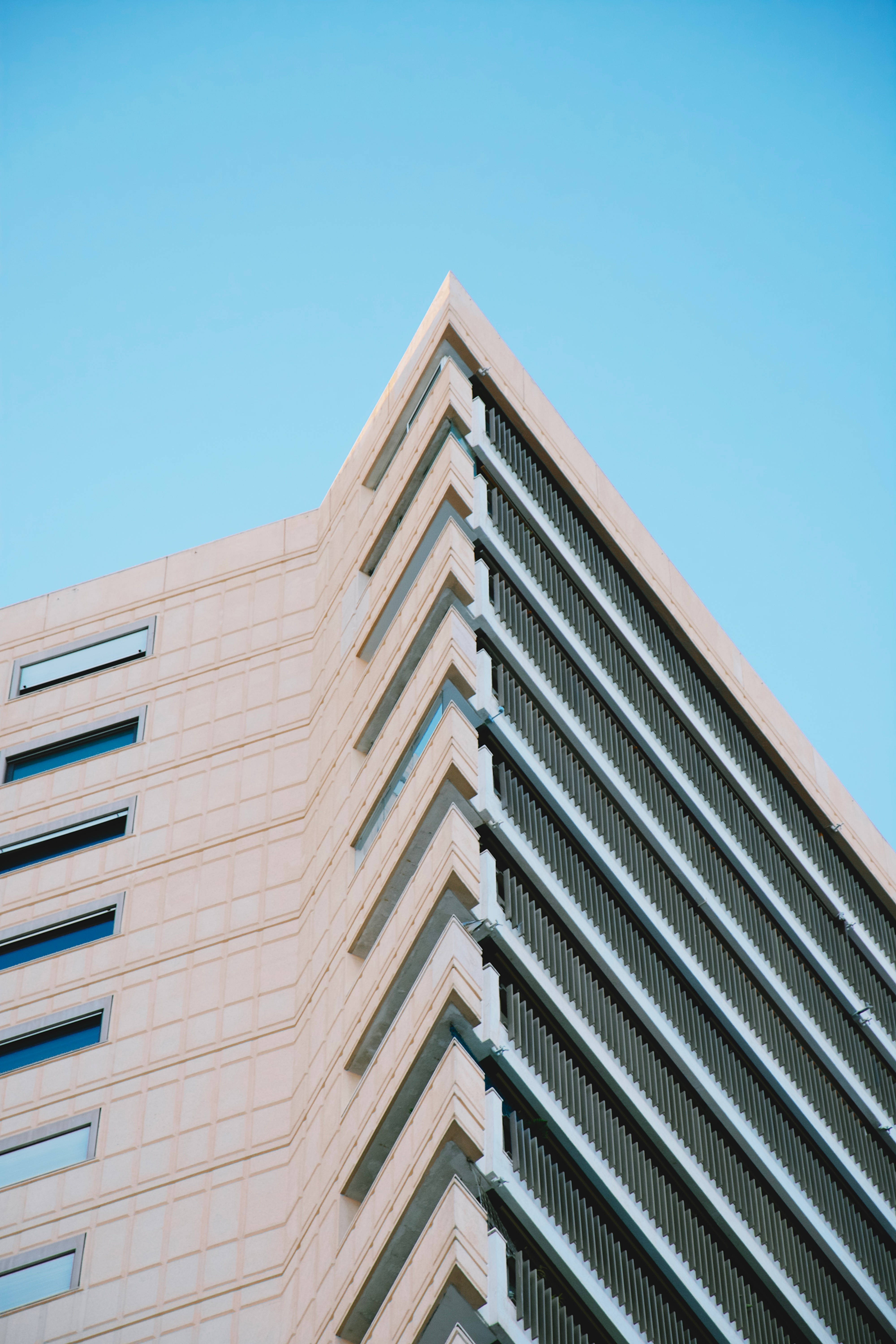 摩納哥建築肖像照 壁紙 — 低角度拍攝現代米色建築物，幾何線條襯托清澈藍天。