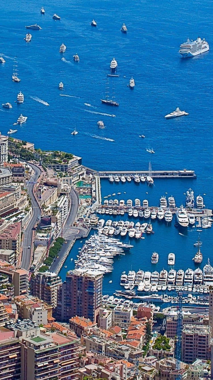 摩納哥海港肖像風景 壁紙 — 摩納哥港口的鳥瞰圖，豪華遊艇和郵輪在充滿活力的藍色海水上熙熙攘攘。