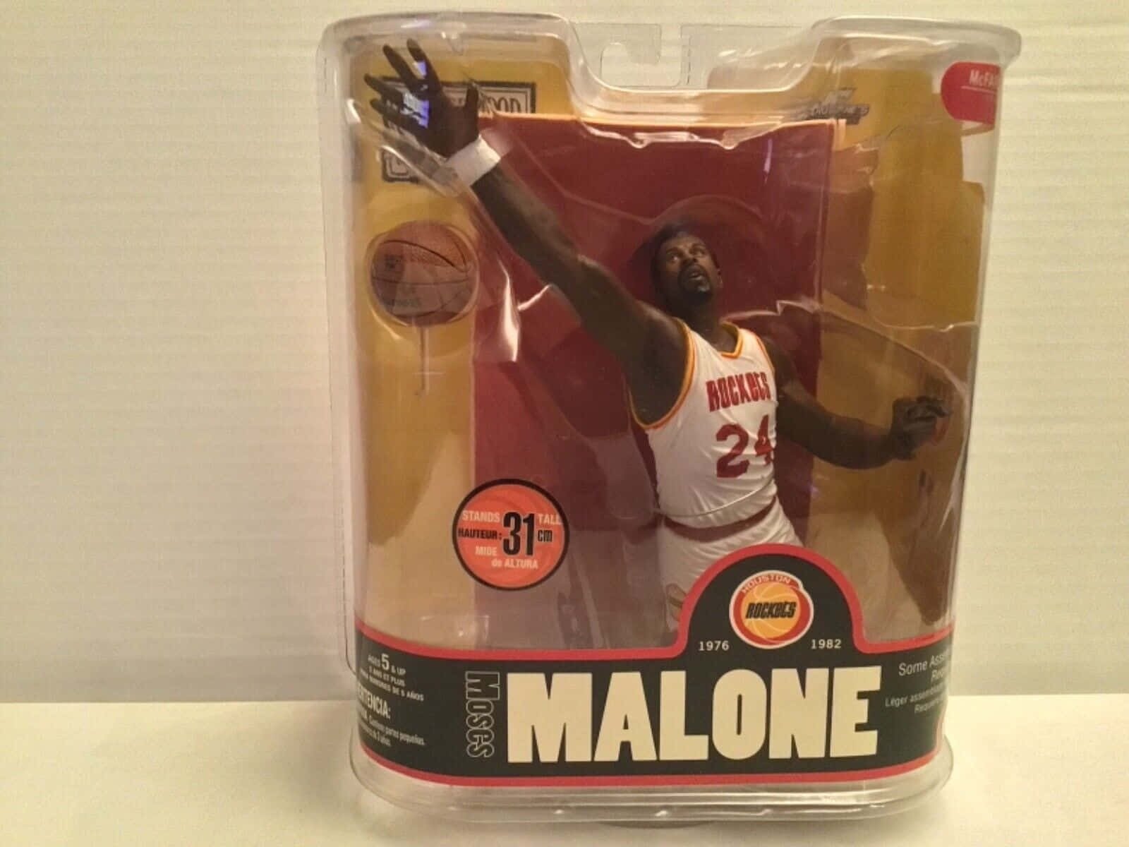 Hakeem Olajuwon 行動人偶，身穿火箭波衫，正在入樽，喺包裝入面。