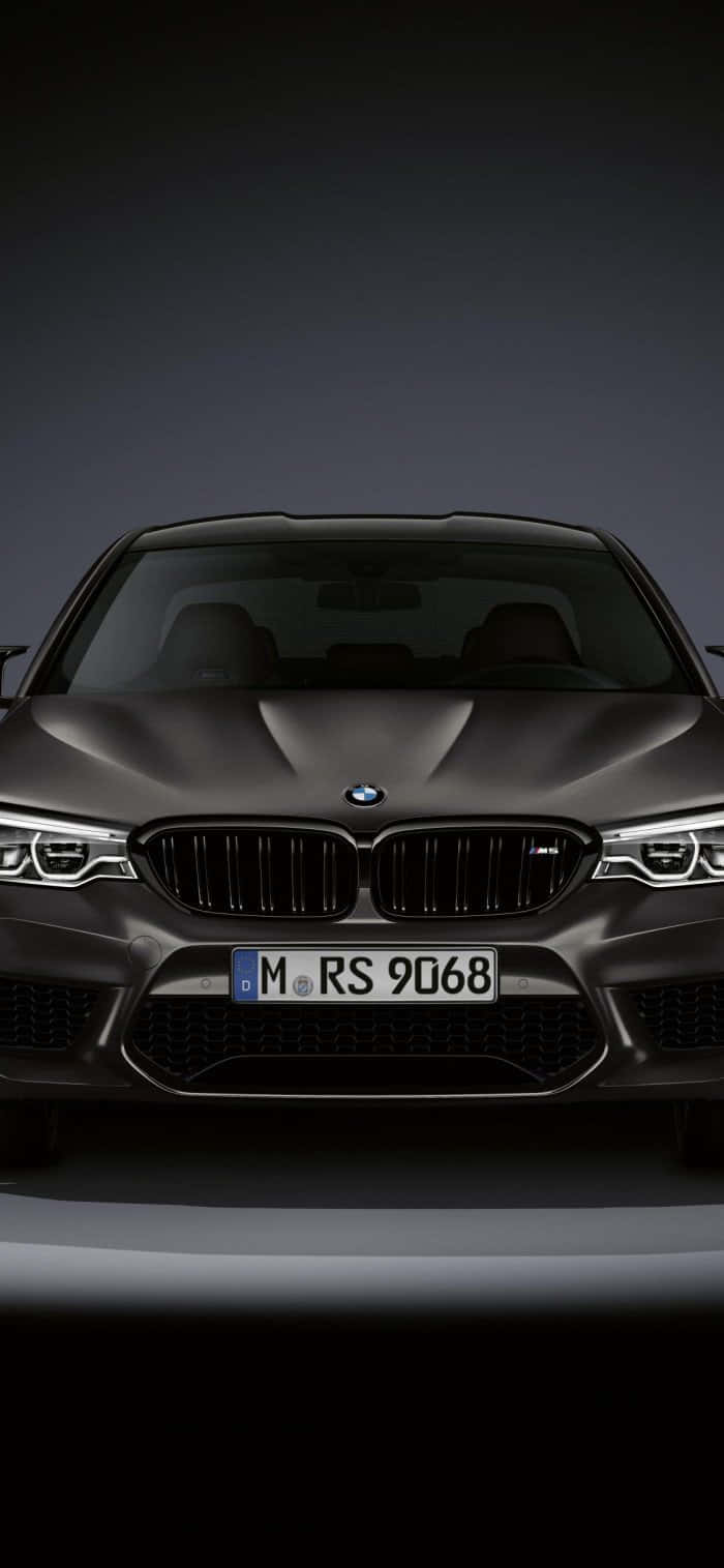 影樓燈光下啞光灰色BMW M5的前視圖。