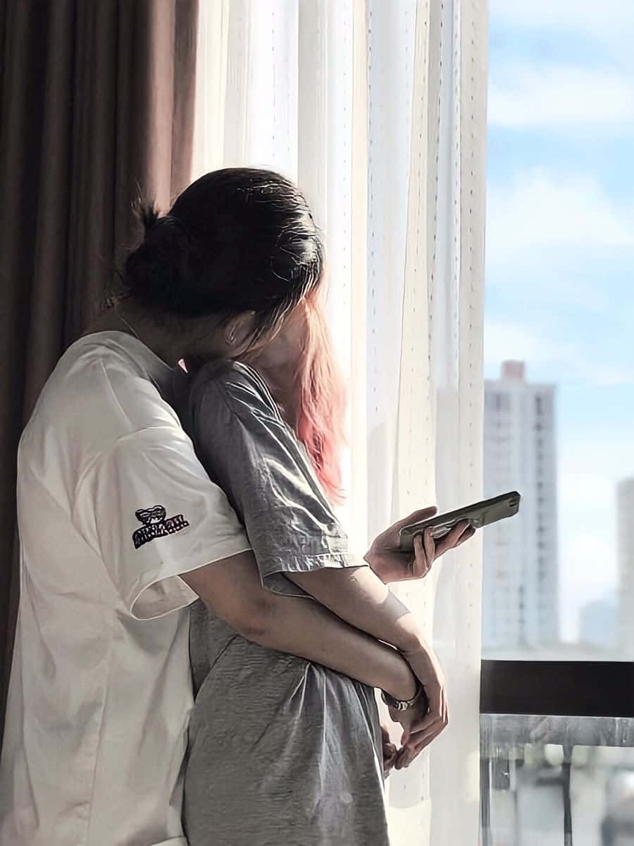 兩人在俯瞰城市的窗邊擁抱。