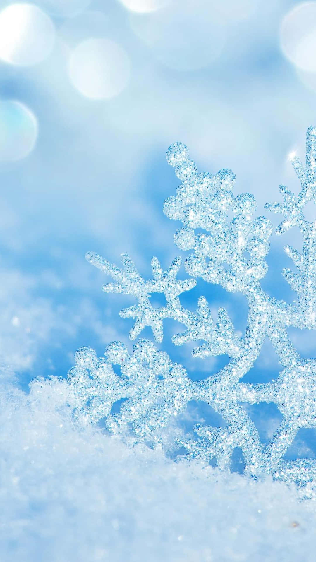 雪地上閃爍的雪花，帶有柔和的藍色散景背景。
