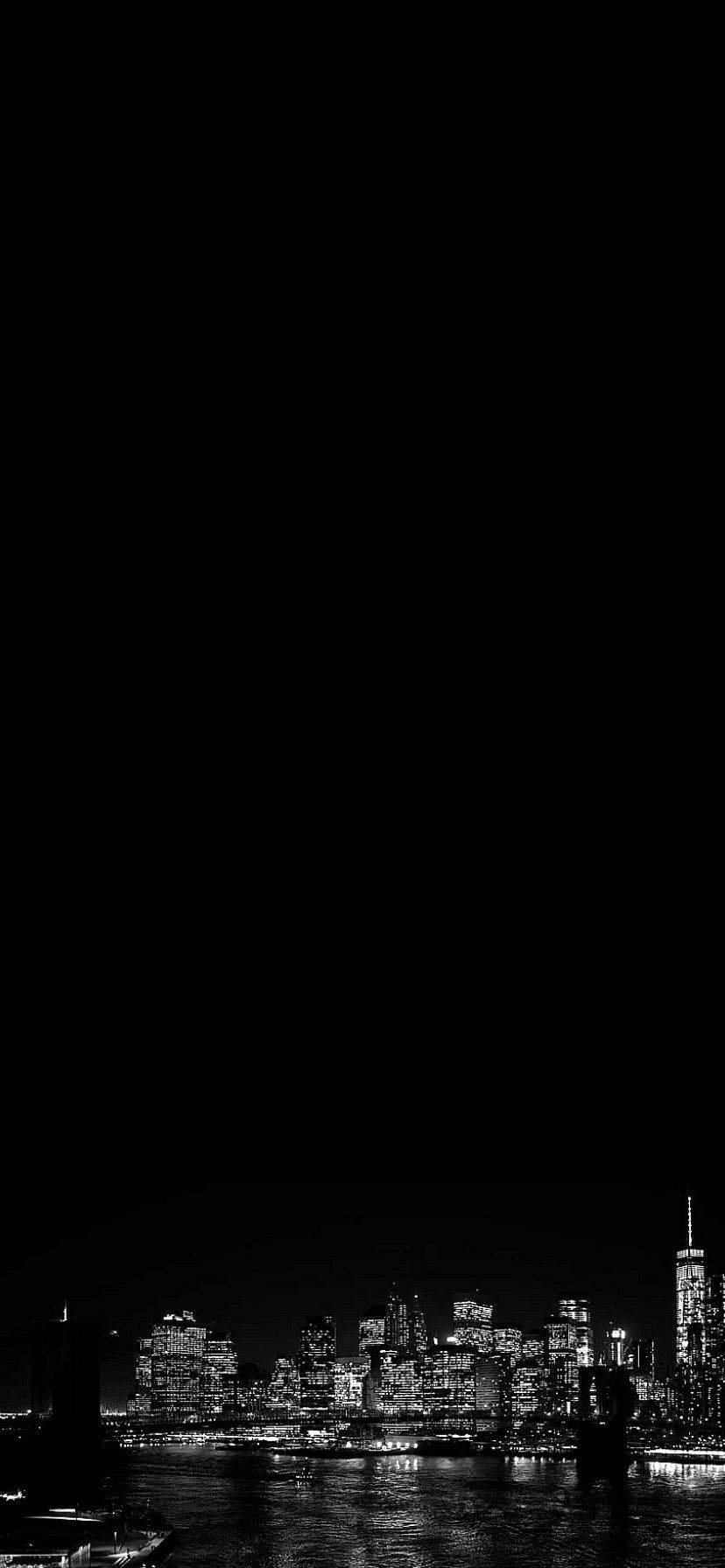 夜間城市天際線，發光的建築物倒映在水中