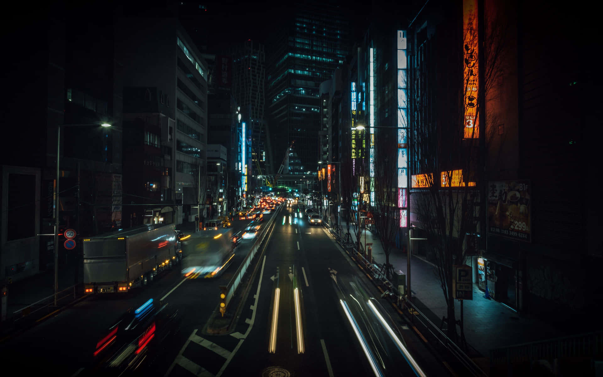 夜晚霓虹燈城市街道，帶有汽車燈光軌跡和高樓大廈。