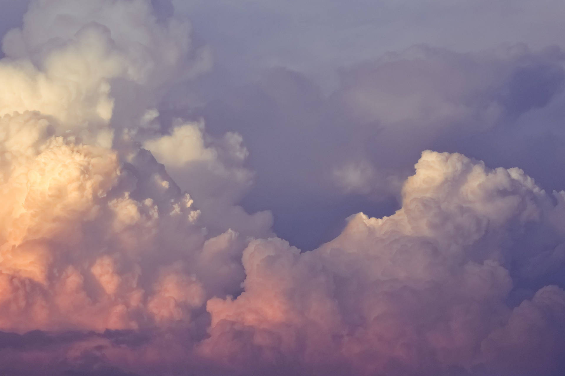 戲劇性的雲朵在紫色暮色天空中散發出橙色和粉紅色調。