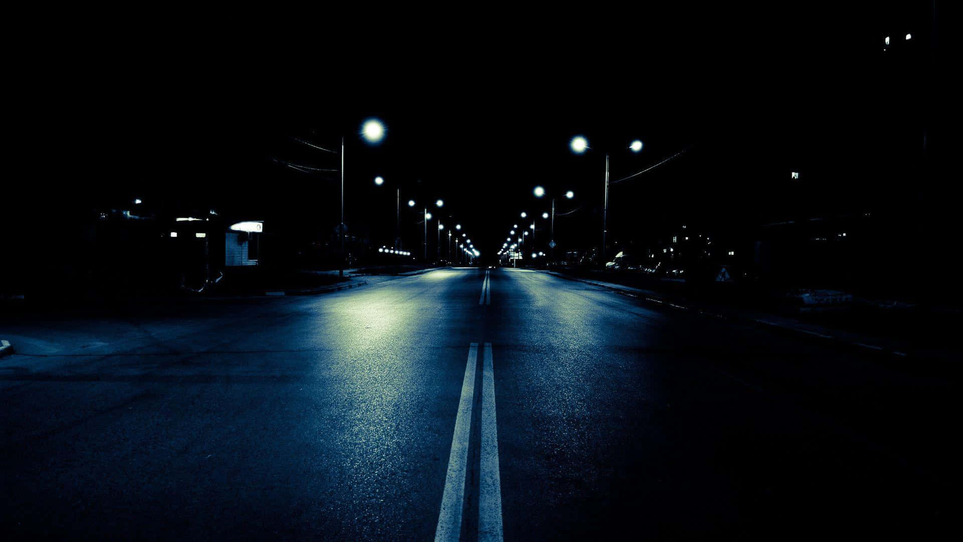 夜晚空曠的道路，路燈在濕路面上反射。