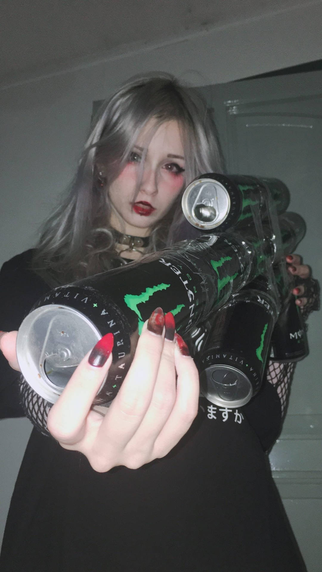 銀髮人士喺室內手持Monster能量飲品。