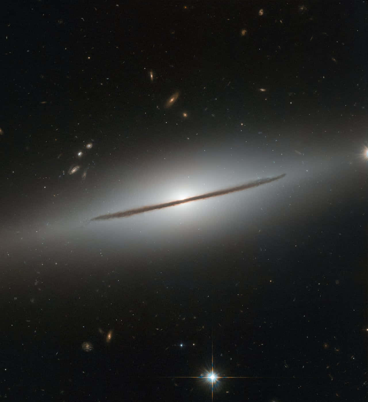 一個發光的側向螺旋星系，被深空中遙遠的恆星和星系包圍。
