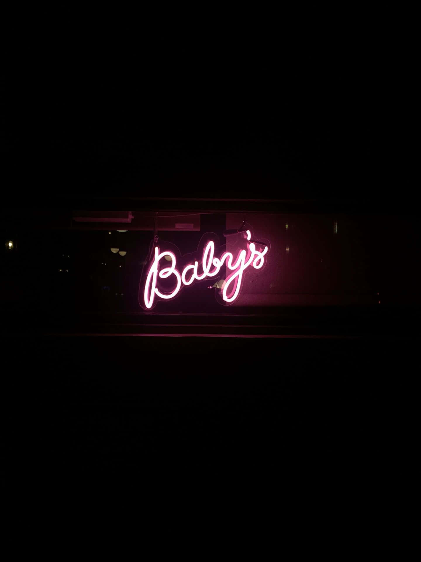 在黑暗中夜晚的粉紅色霓虹燈牌，上面寫著Baby's。