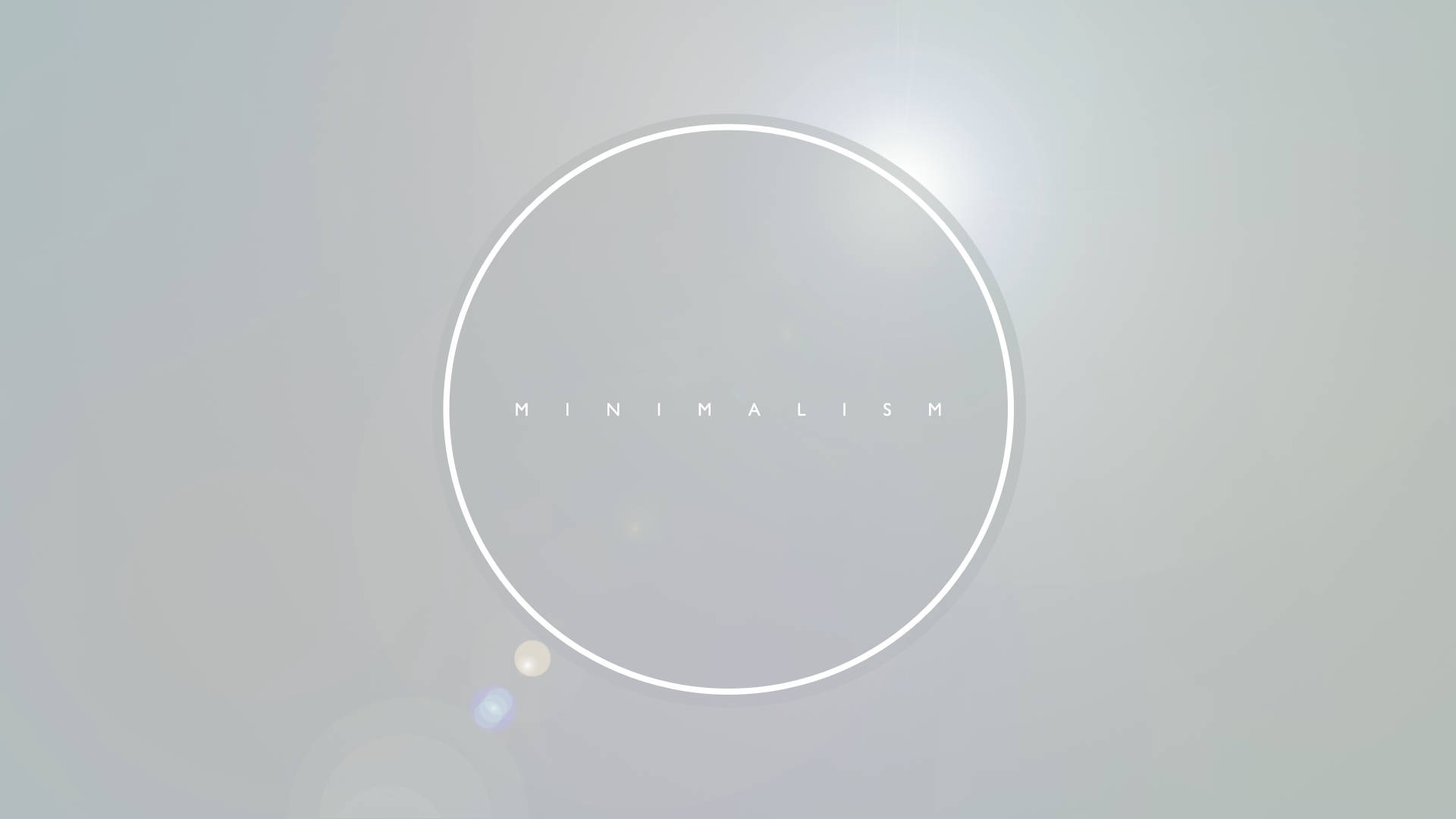 一個發光的白色圓圈，內有「minimalism」一詞，位於柔和的灰色背景上。