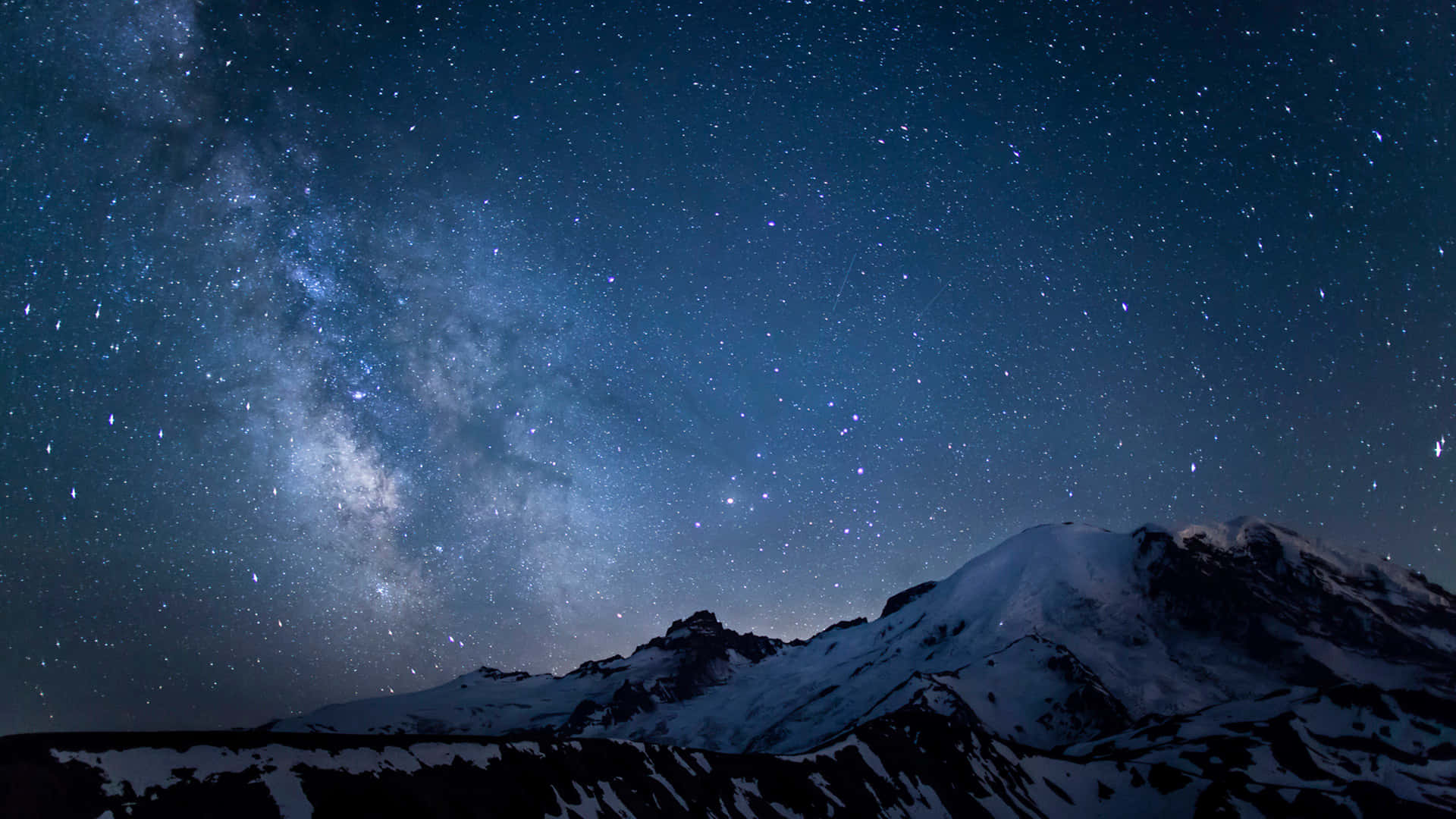 積雪的山脈在充滿活力的星空下，銀河系清晰可見。