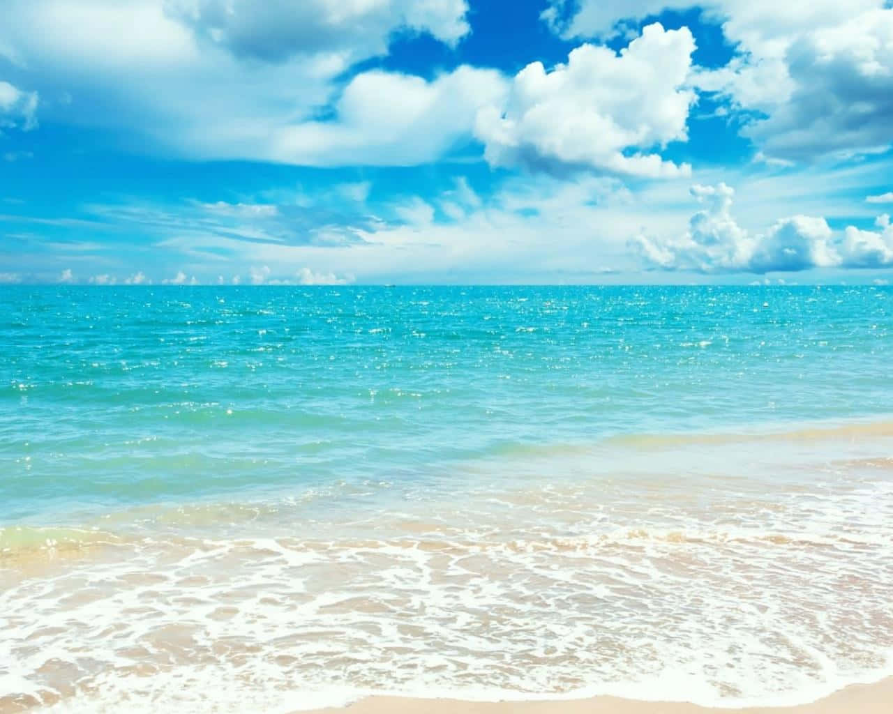 擁抱陽光：在晴朗日子享受海灘假期 壁紙 — 充滿活力的綠松色海浪輕輕拍打著金色的沙灘，上方是明亮的藍天，點綴著蓬鬆的白雲。