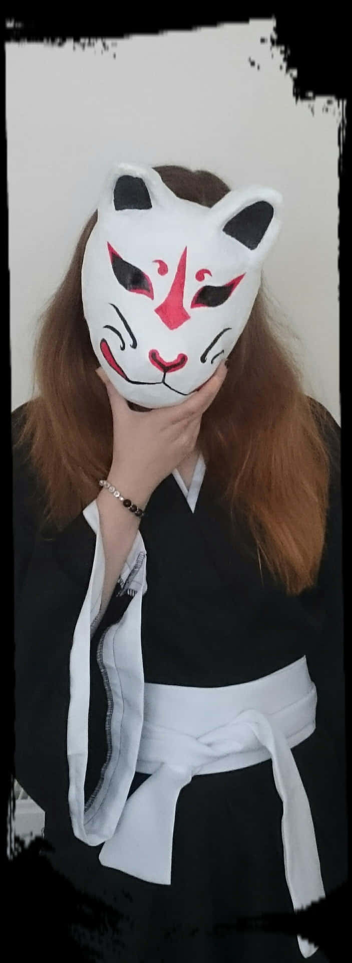 穿著和服的人戴著狐狸面具遮住臉。
