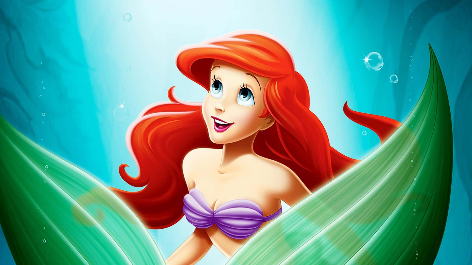 The Little Mermaid 桌布 壁紙 — 擁有鮮艷紅髮和紫色上衣的美人魚艾莉爾在海底綠色海草間愉快微笑。