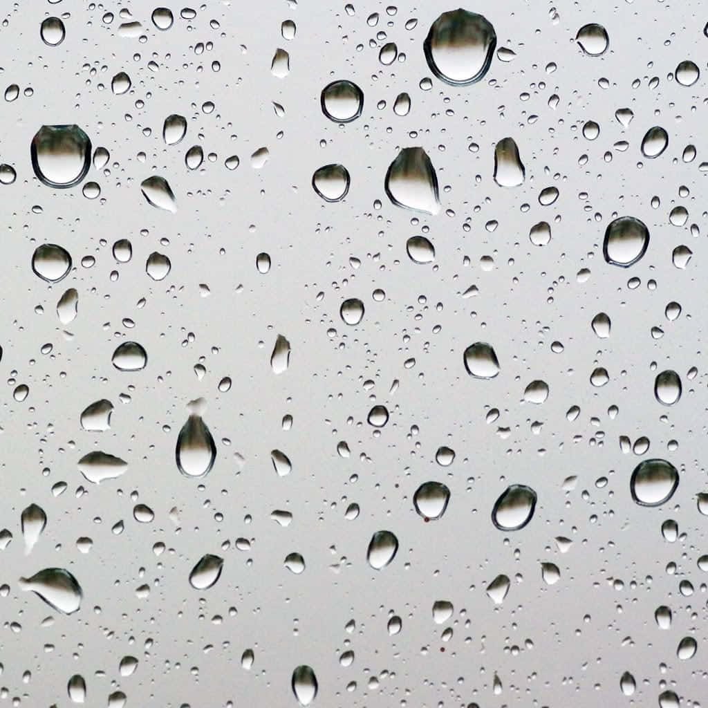 玻璃窗上的雨滴映照灰色天空