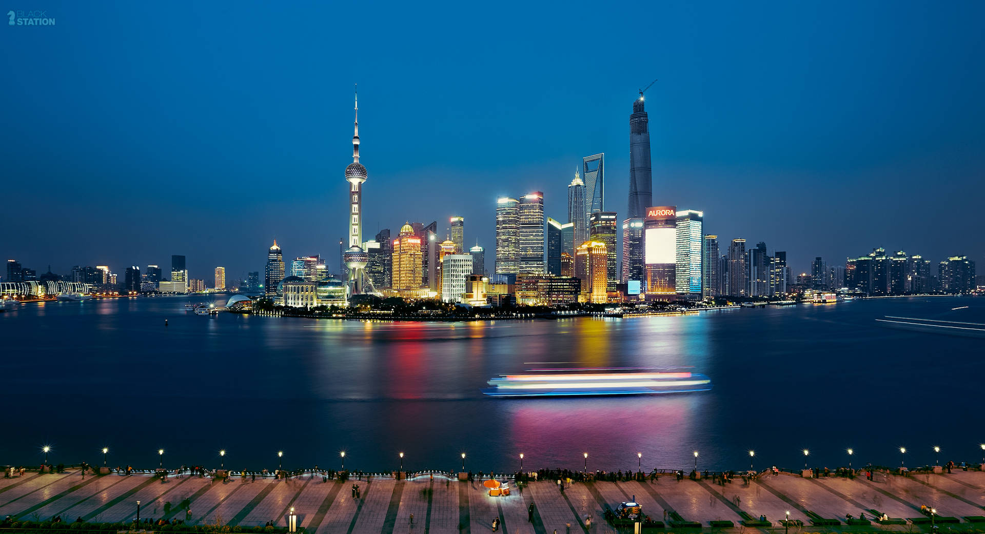 上海夜景天際線，發光的建築物和河上的小船。