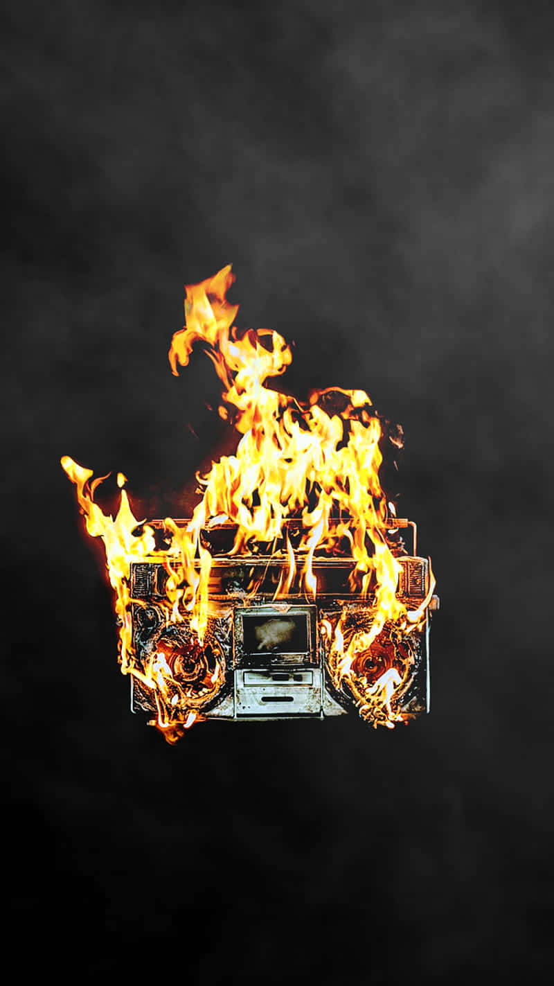 收音機在火中數位藝術 壁紙 — 一部復古手提音響被咆哮的火焰吞噬，背景是煙霧瀰漫的黑暗。