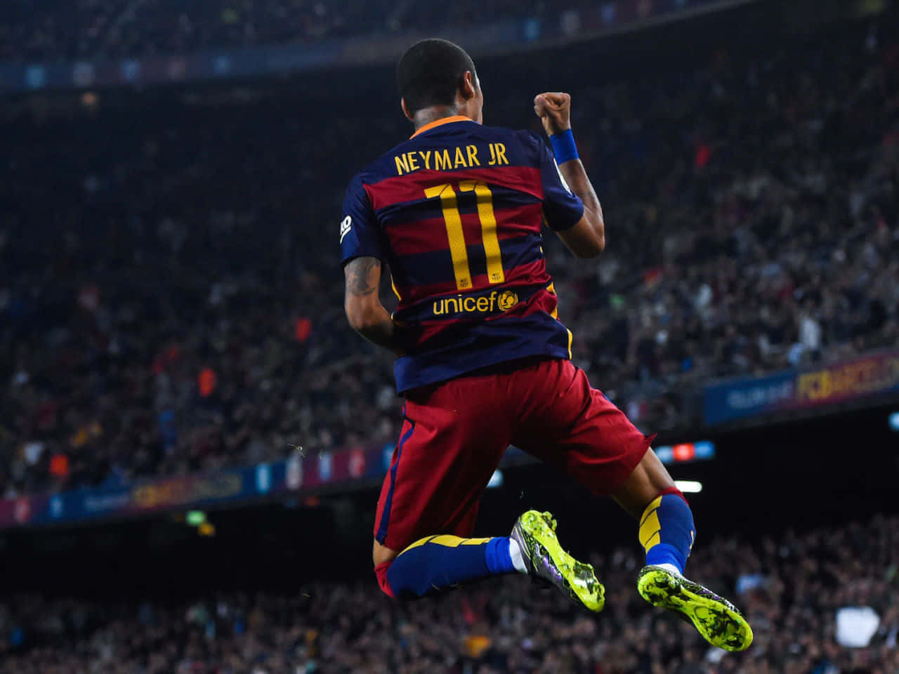 足球運動員尼馬（Neymar Jr.）在夜間於體育館跳起慶祝入球。