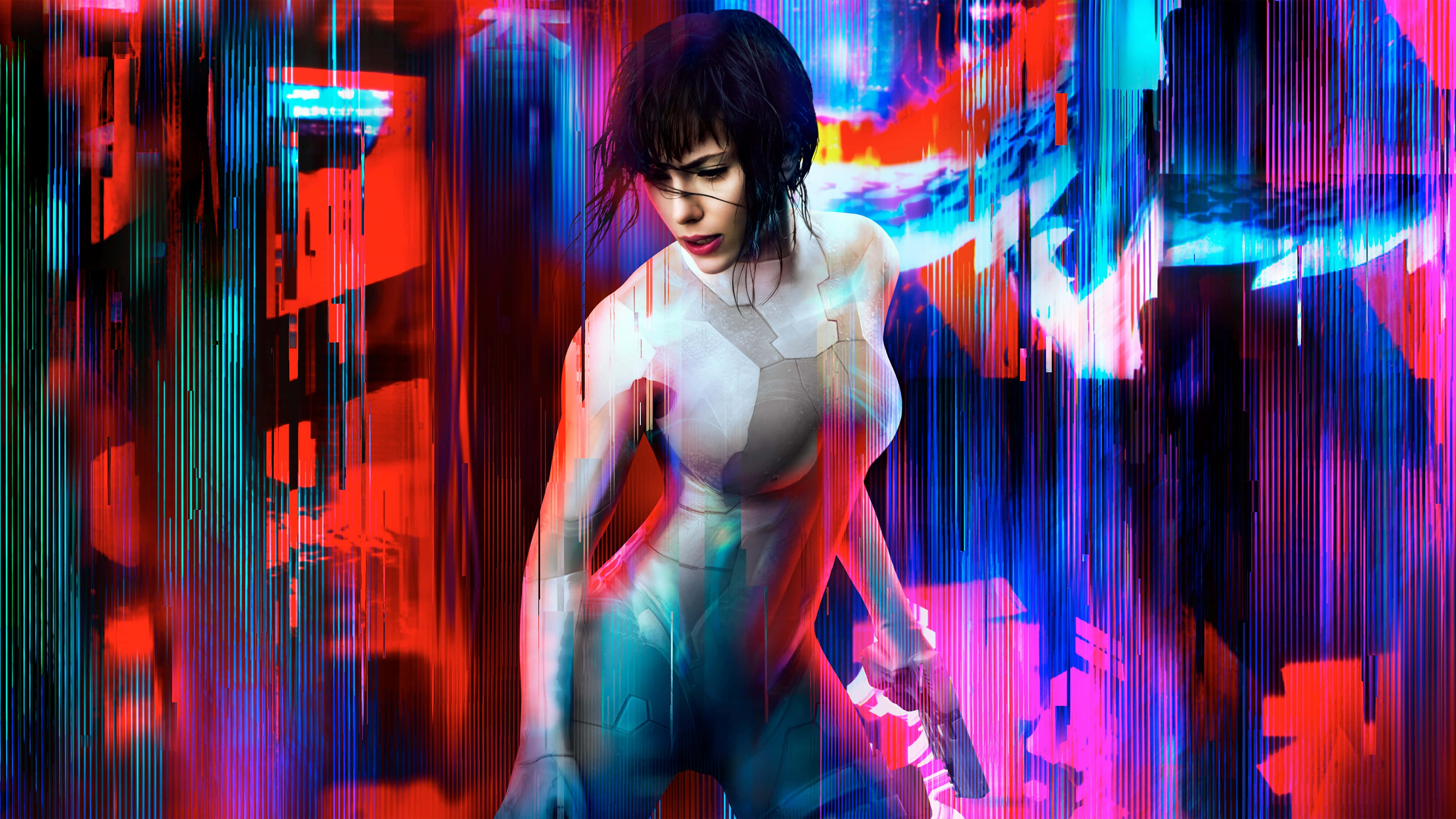 《攻殼機動隊》中的 Major Motoko Kusanagi 準備迎戰 壁紙 — 一位穿著發光白色套裝的賽博龐克女性，站在充滿活力的紅色、藍色和紫色數位故障效果之中。