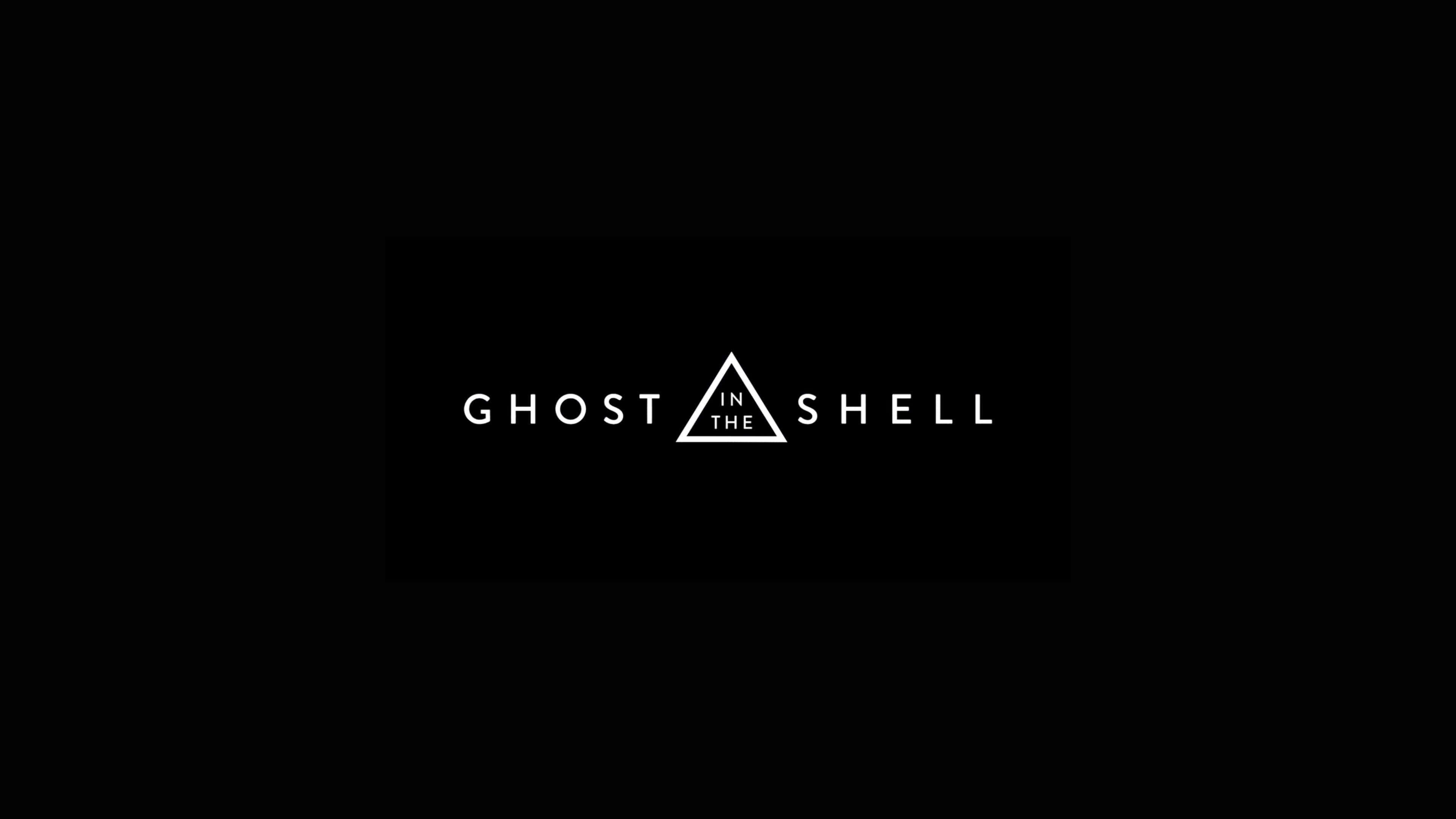 《攻殼機動隊》標誌性主角 Major Kusanagi 壁紙 — Ghost in the Shell 標誌以白色文字和三角形居中在純黑色背景上。