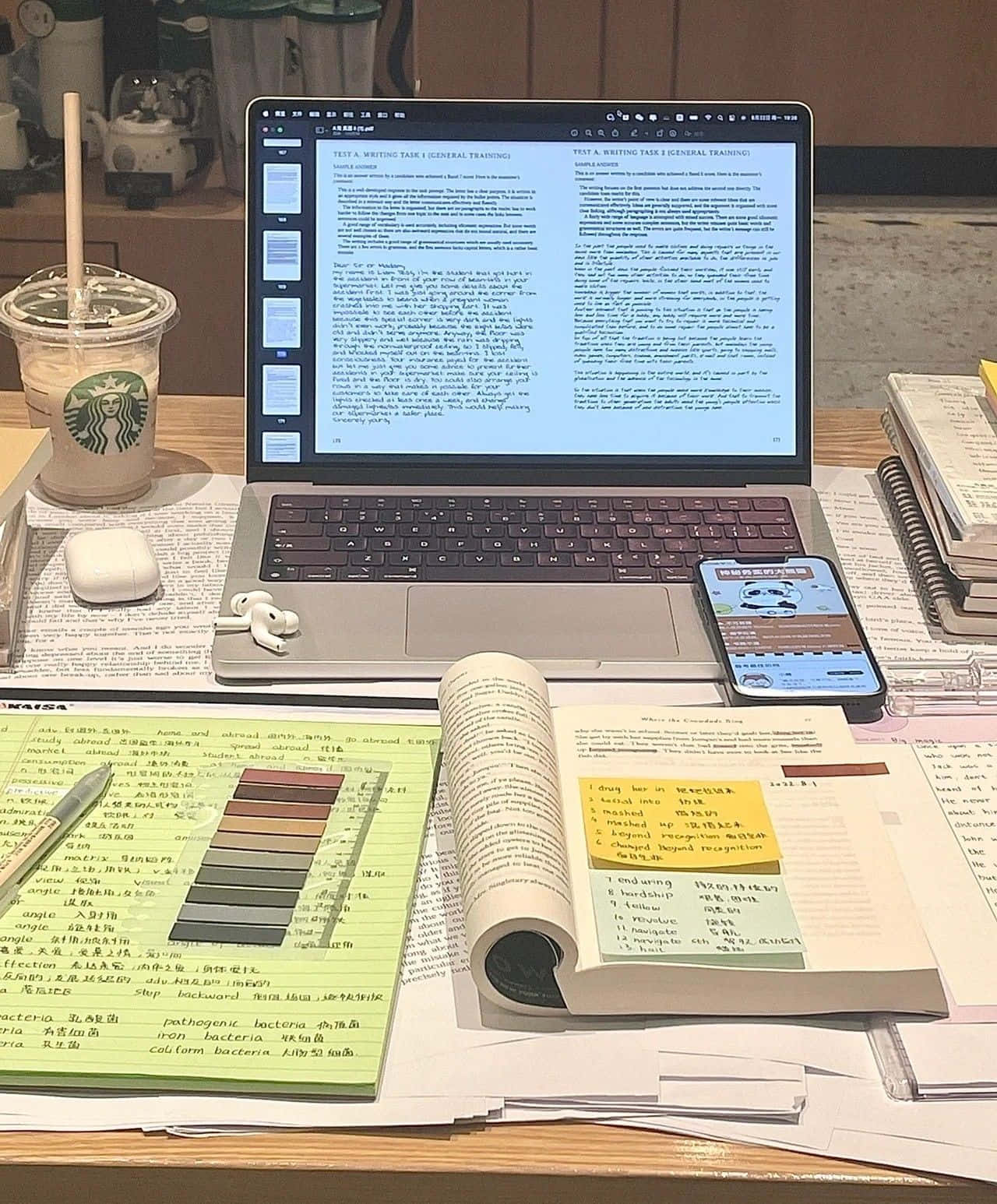放有手提電腦、筆記簿及其他物品的書桌 壁紙