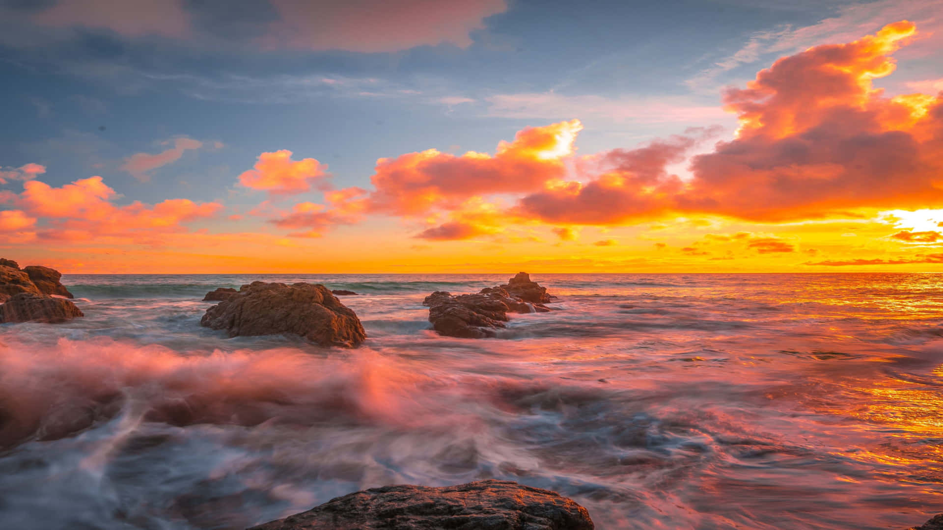 夕陽下的海洋，海浪拍打岩石