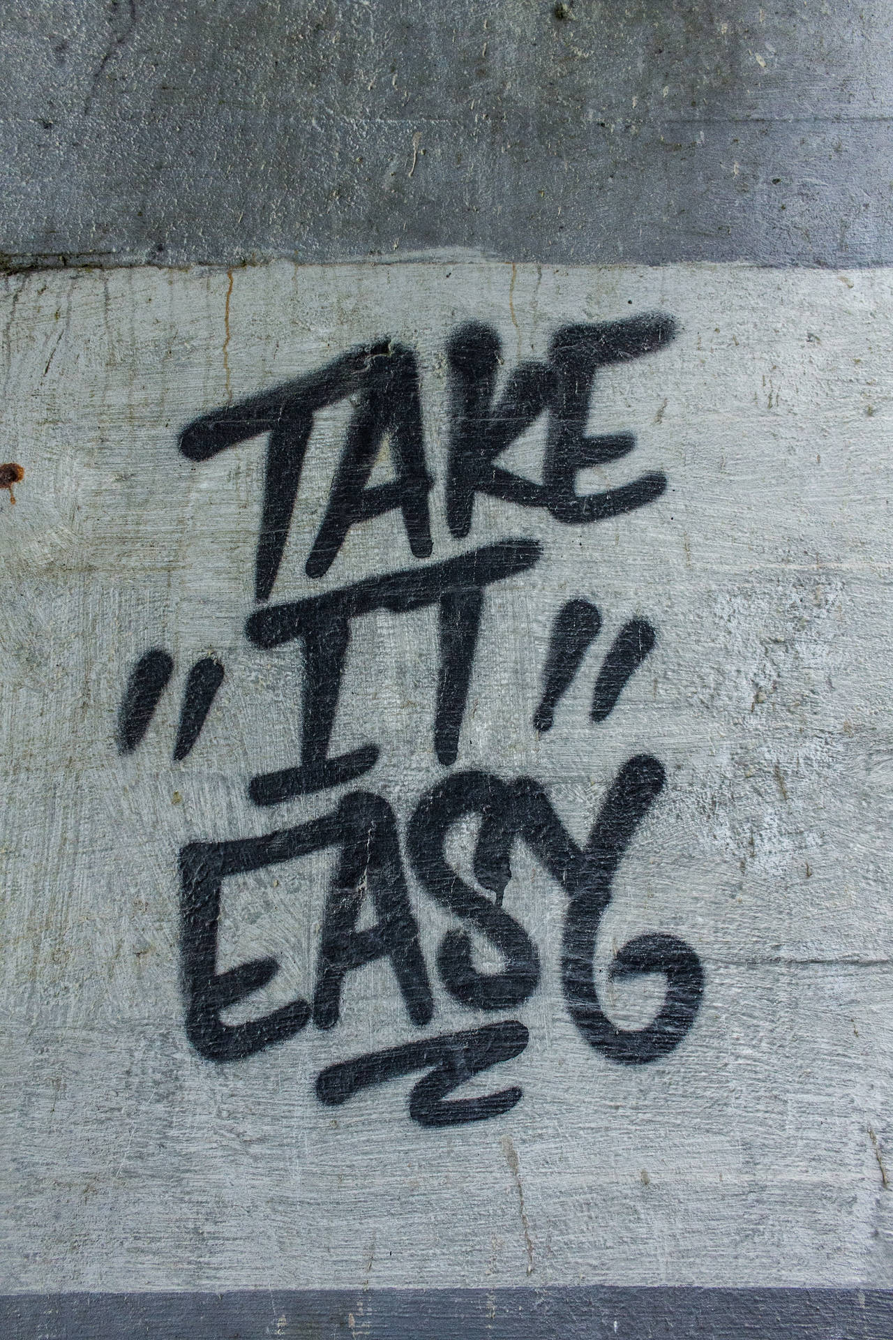 裂縫混凝土牆上的塗鴉訊息 take it easy